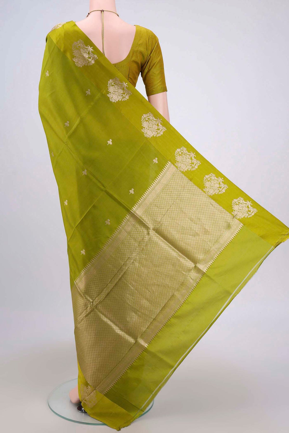 Flat view of Parrot Green Banarasi Katan Silk Saree with Zari Butta on the body and Zari Border. 