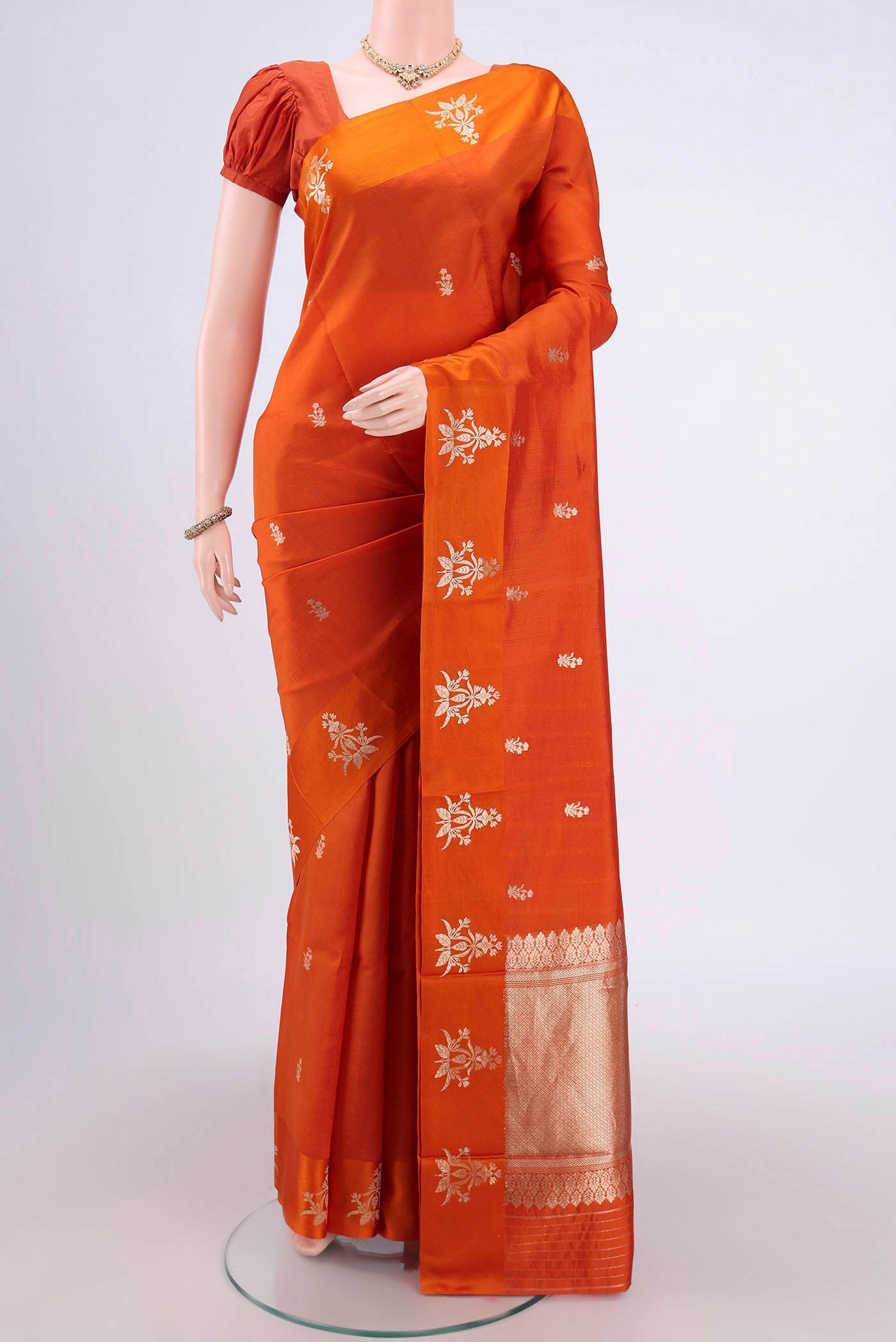 Orange Banarasi Katan Silk Saree with Zari Butta on the body and Zari Border.  displayed on a mannequin