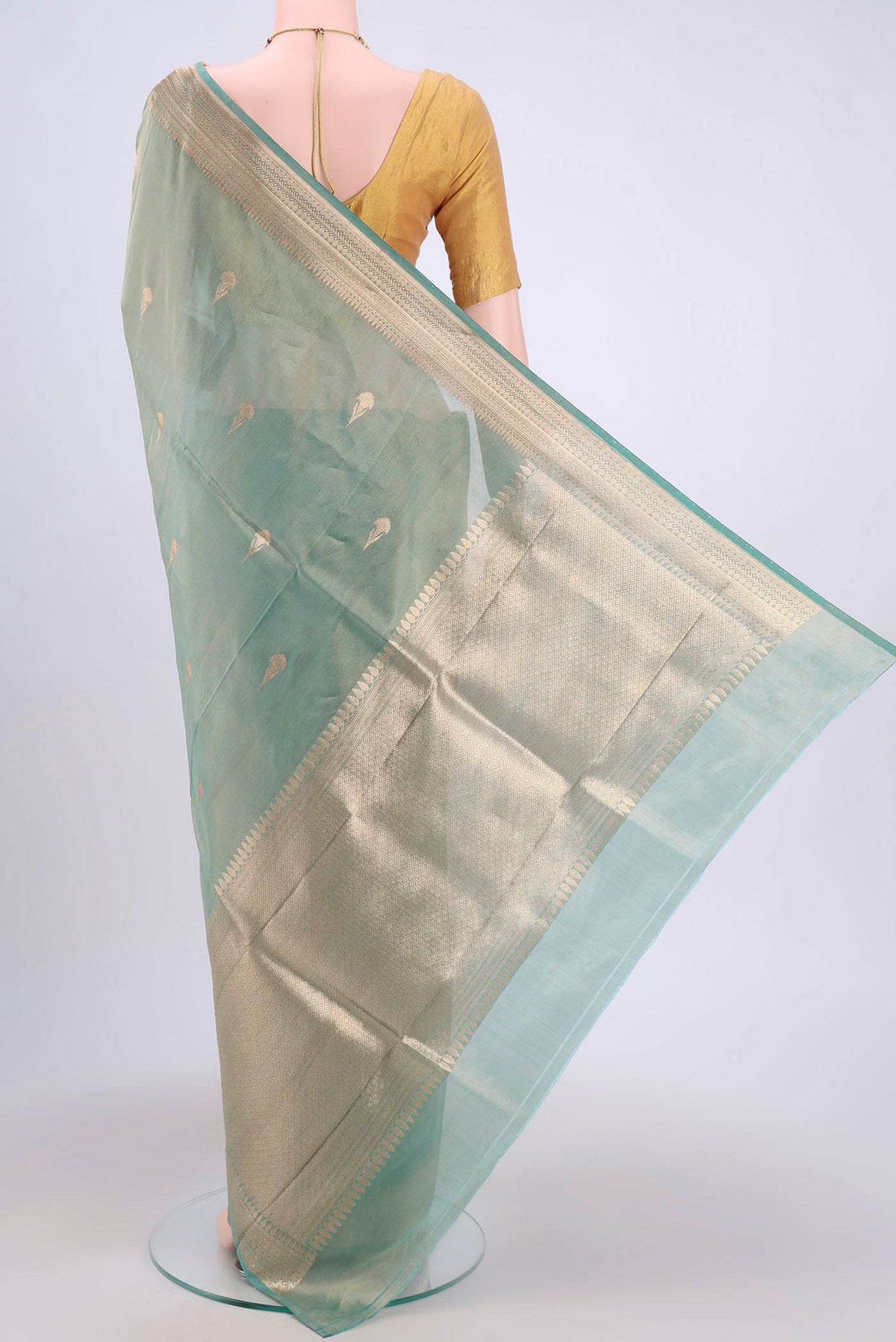 Flat view of Sea Green Banarasi Tissue Silk Saree with Zari Butta on the body and Zari Border. 