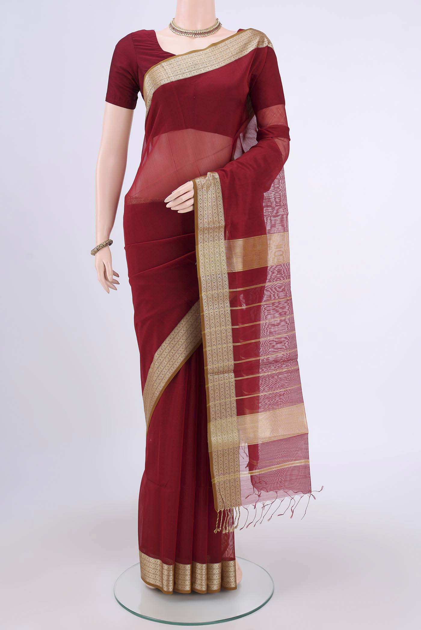 Maroon Maheshwari Silk Cotton Saree with Plain Body and Thread Border.  displayed on a mannequin