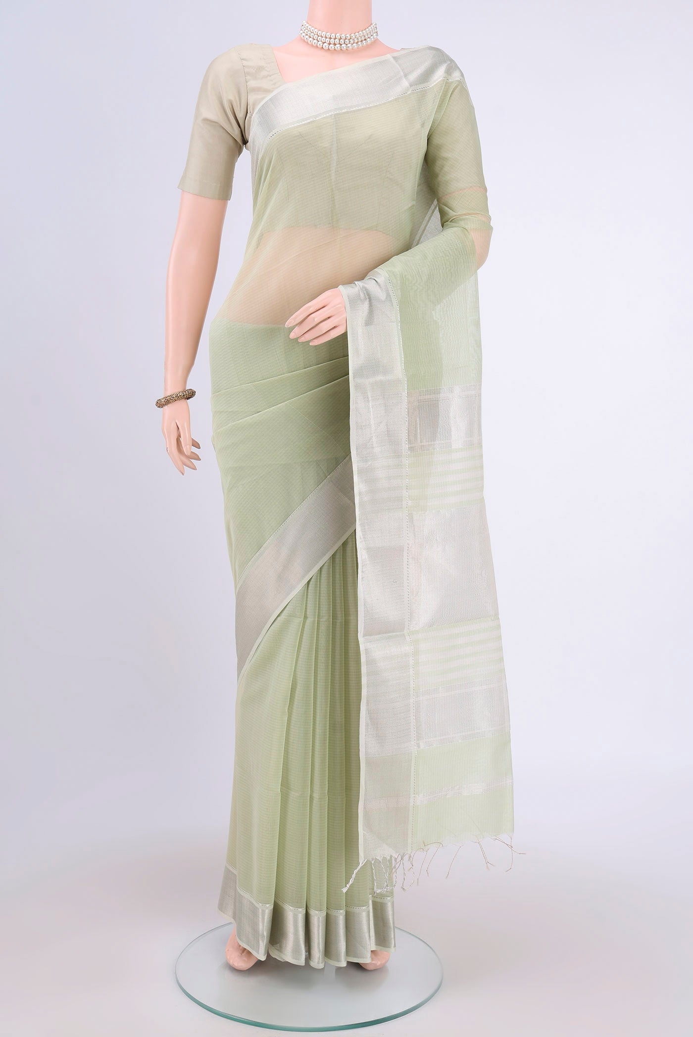 Sage Green Maheshwari Silk Cotton Saree with Plain Body and Zari Border.  displayed on a mannequin
