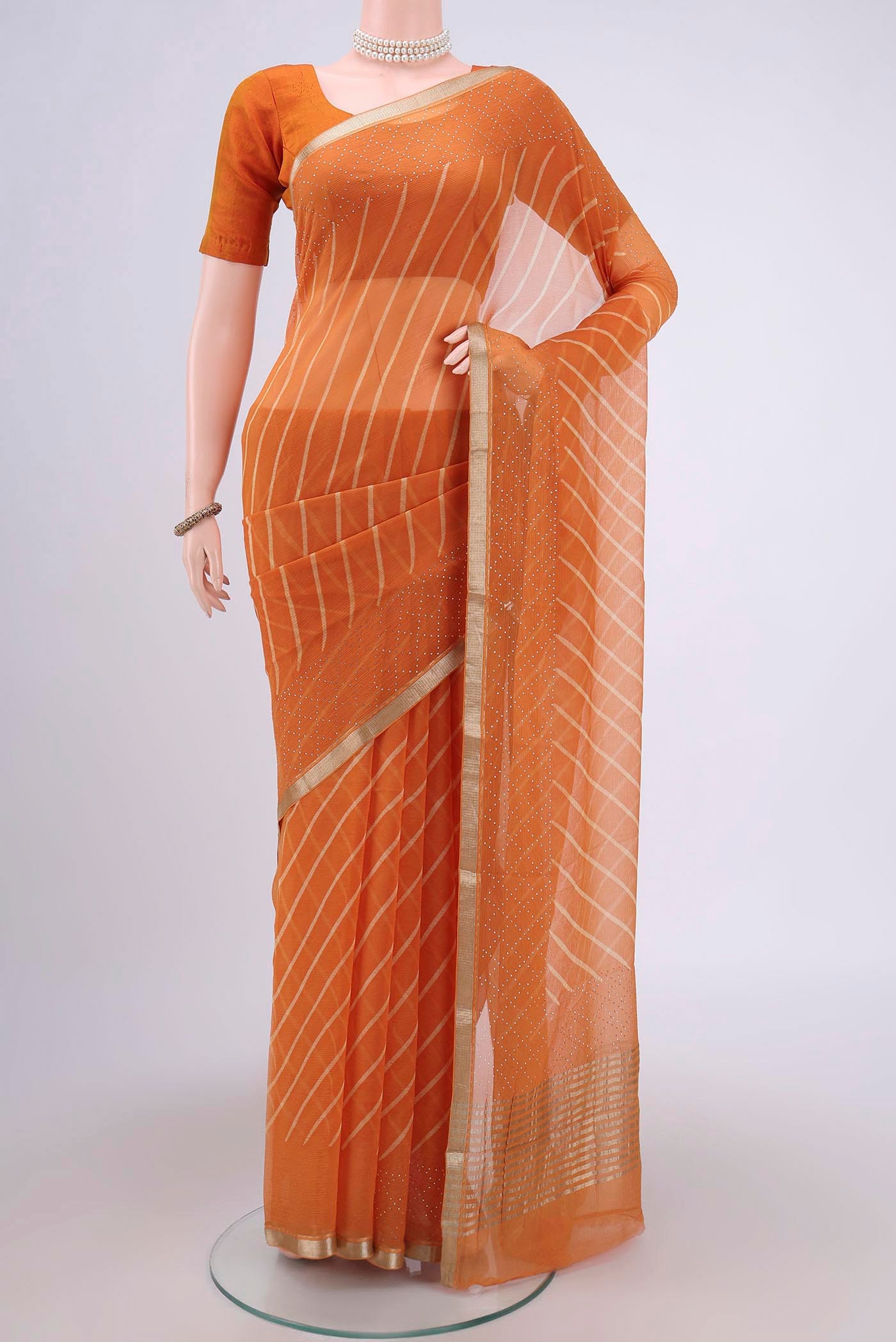 Brick Orange Mysore Chiffon Saree with Printed design on the body and Zari Border.  displayed on a mannequin