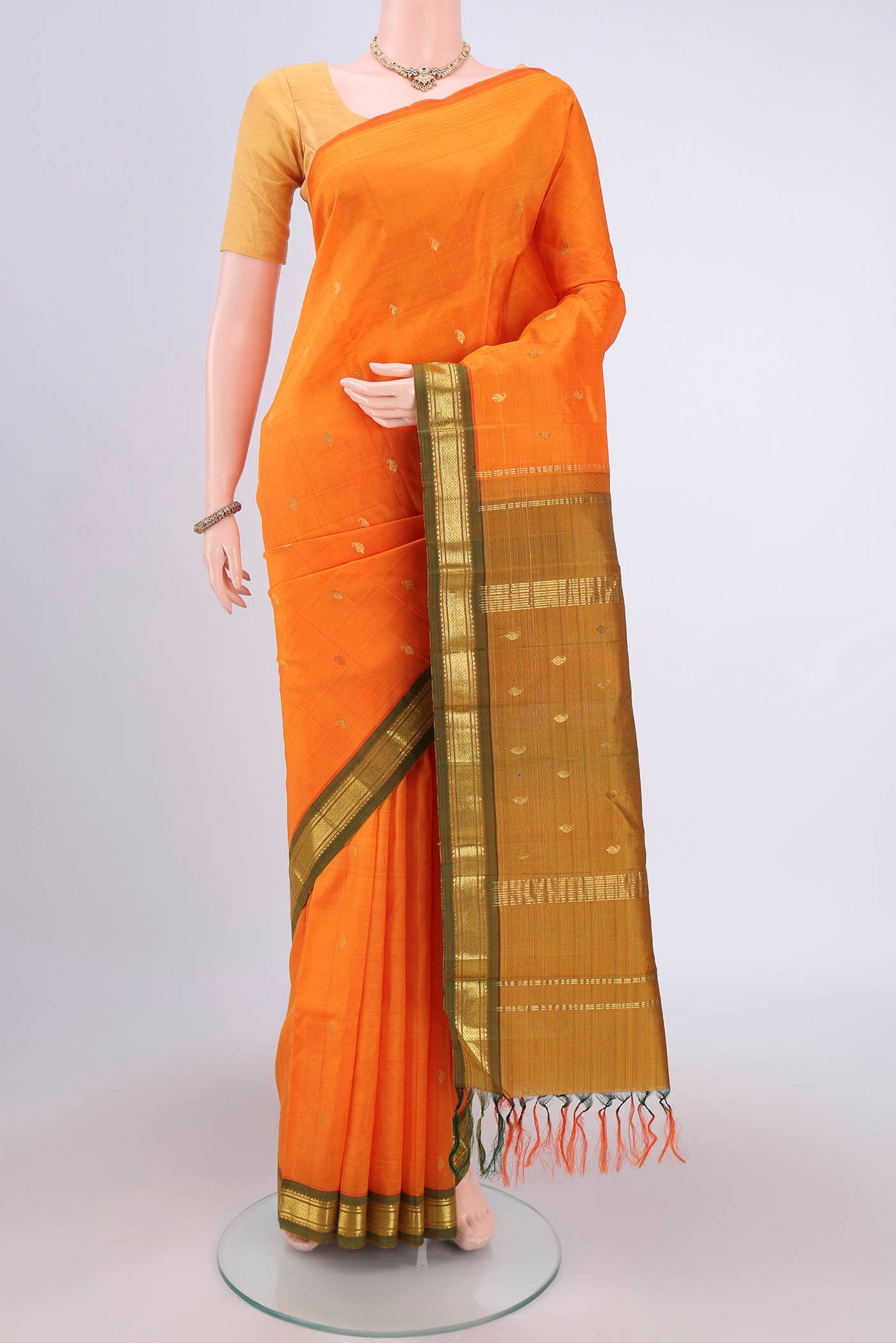 Orange Kanjivaram Silk Saree with Zari Butta on the body and One Side Border.  displayed on a mannequin