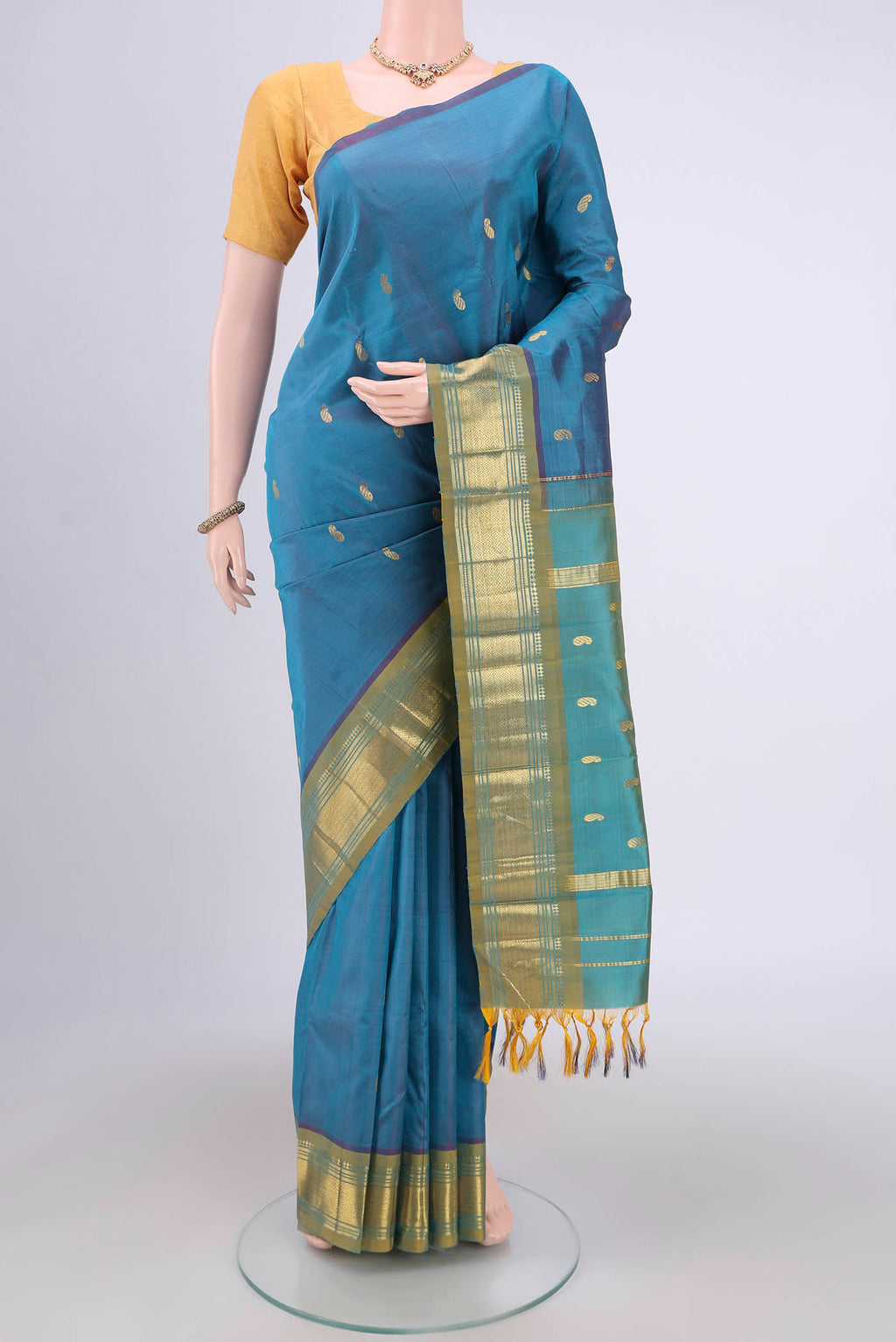 Light Blue Kanjivaram Silk Saree with Zari Butta on the body and One Side Border.  displayed on a mannequin