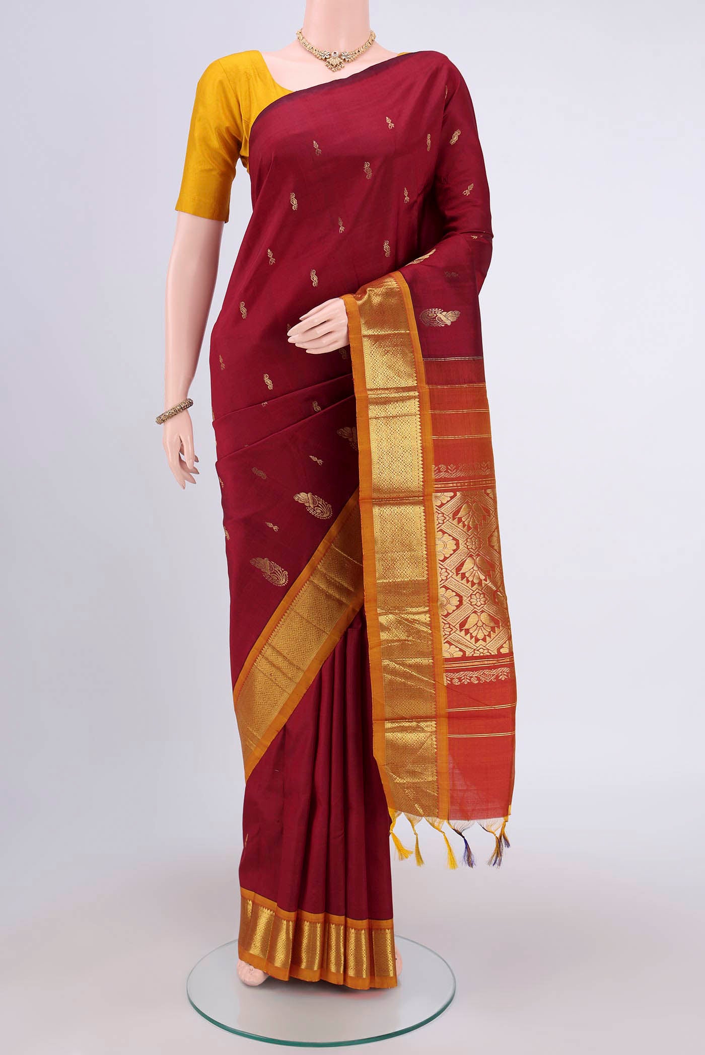 Green Kanjivaram Silk Saree with Zari Butta on the body and One Side Border.  displayed on a mannequin