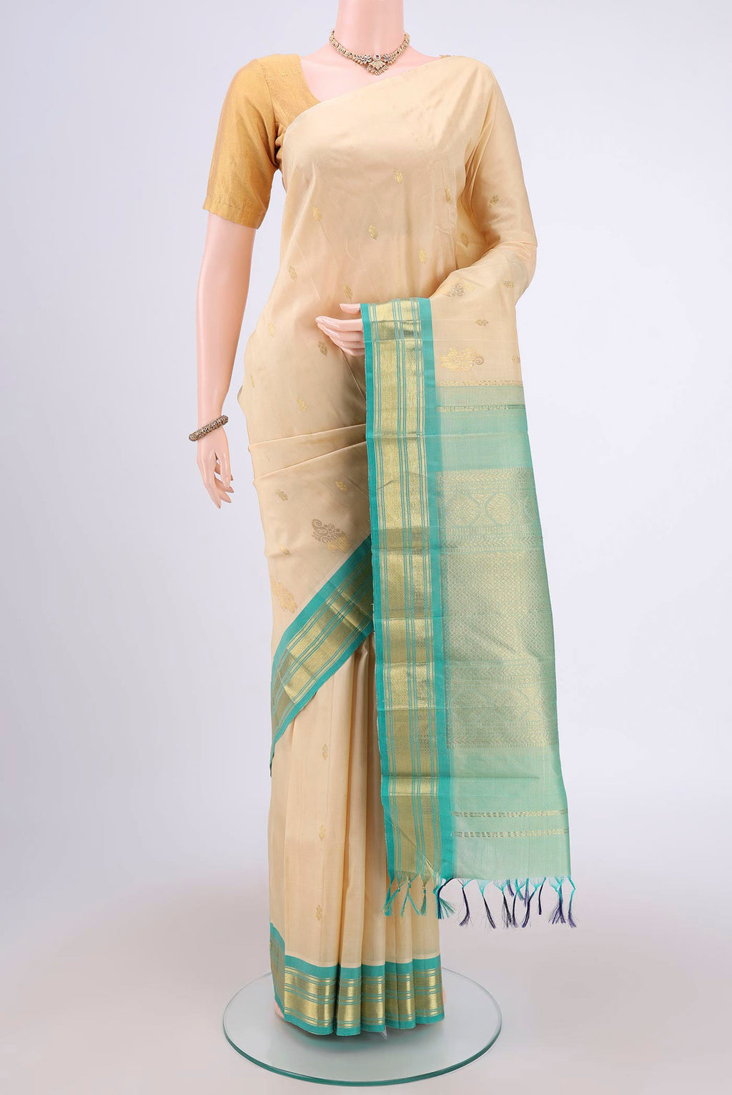 Cream Dual Tone Kanjivaram Silk Saree with Zari Butta on the body and One Side Border.  displayed on a mannequin