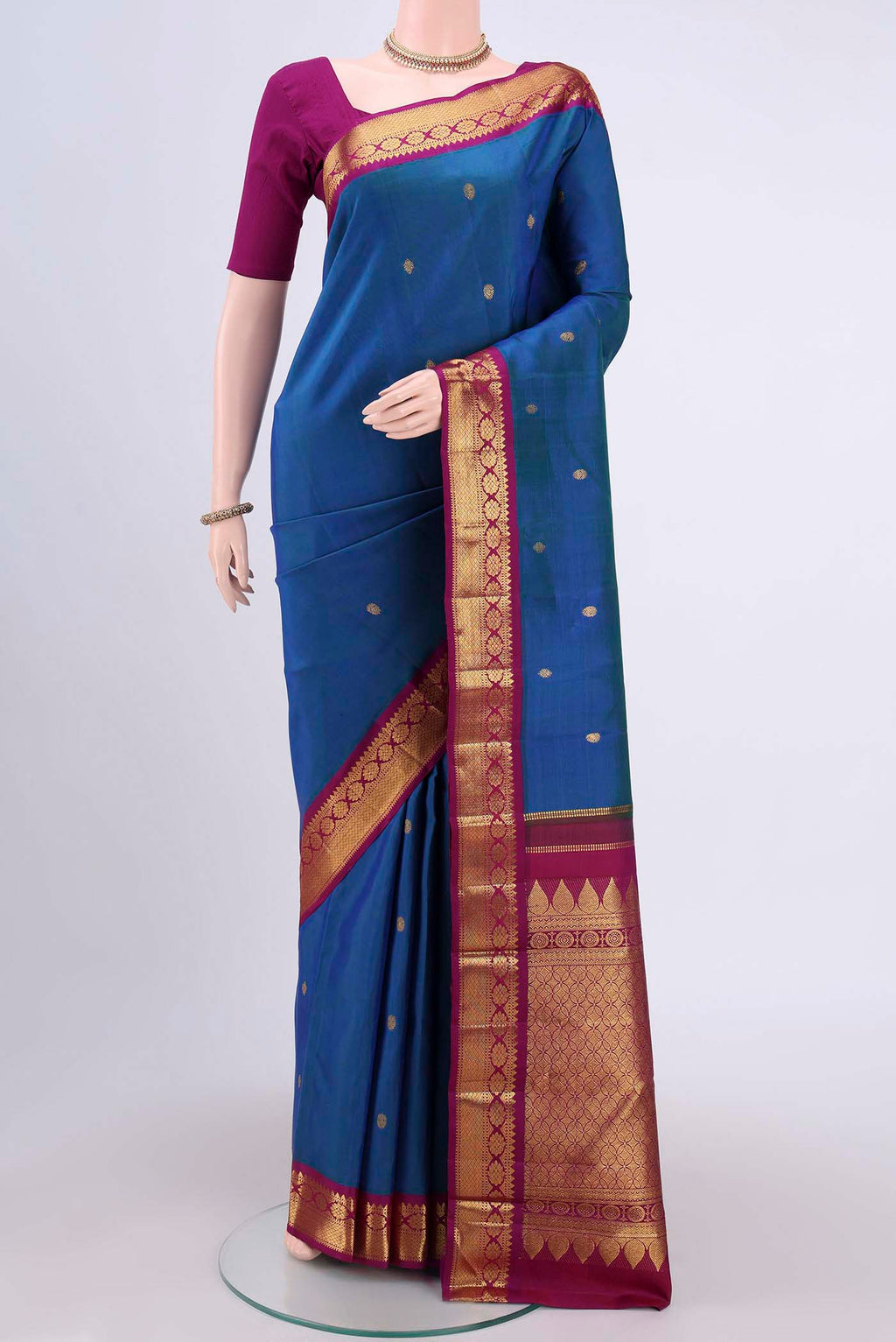 Peacock Blue Kanchipuram Saree with Zari Butta on the body and Zari Border.  displayed on a mannequin
