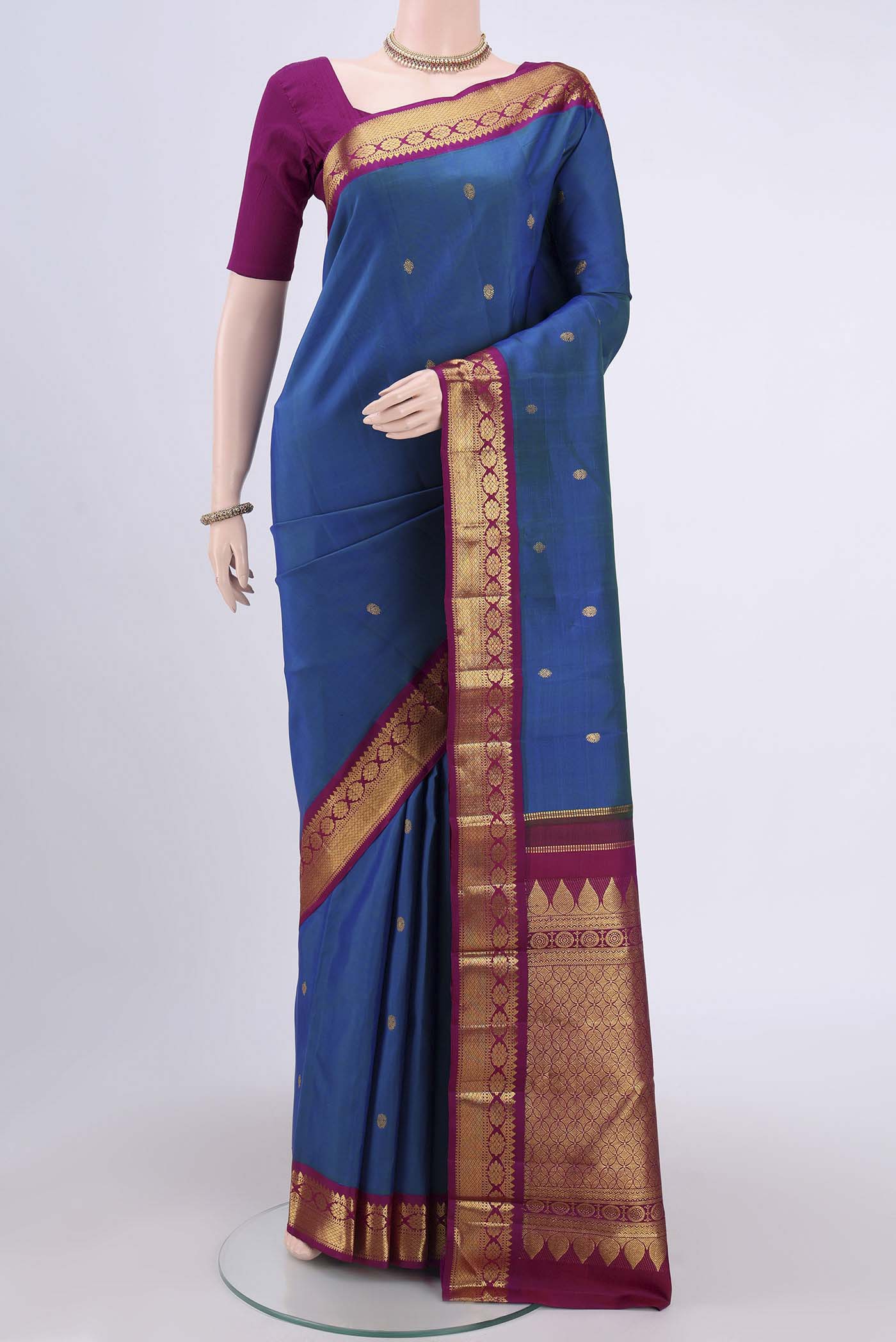 Peacock Blue Kanchipuram Saree with Zari Butta on the body and Zari Border.  displayed on a mannequin
