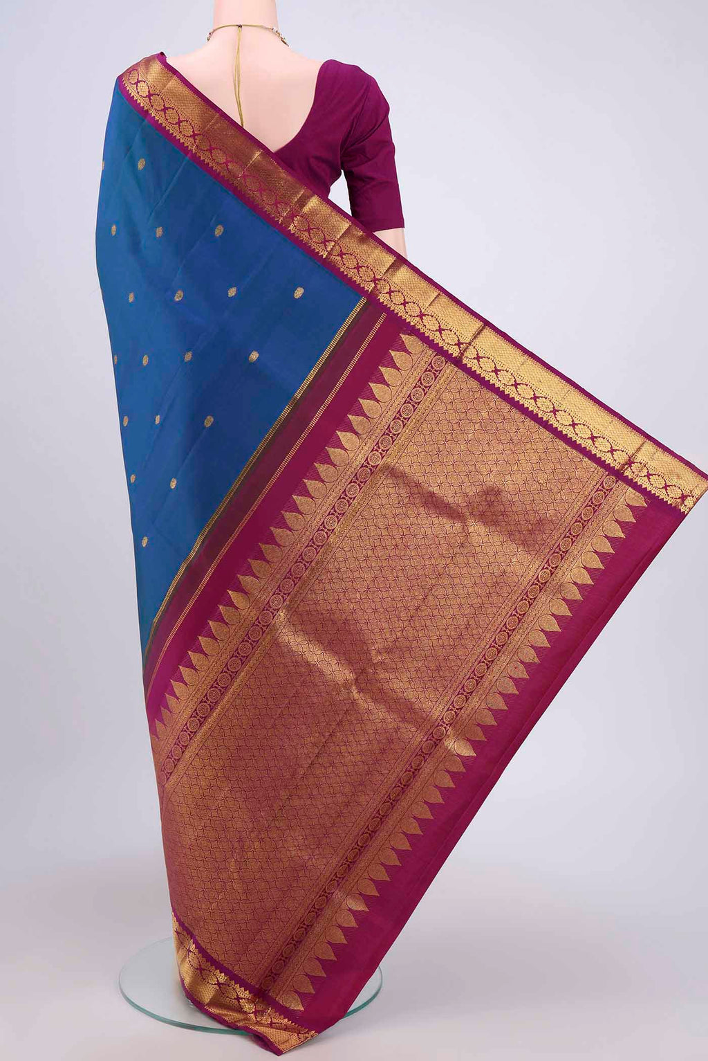 Flat view of Peacock Blue Kanchipuram Saree with Zari Butta on the body and Zari Border. 
