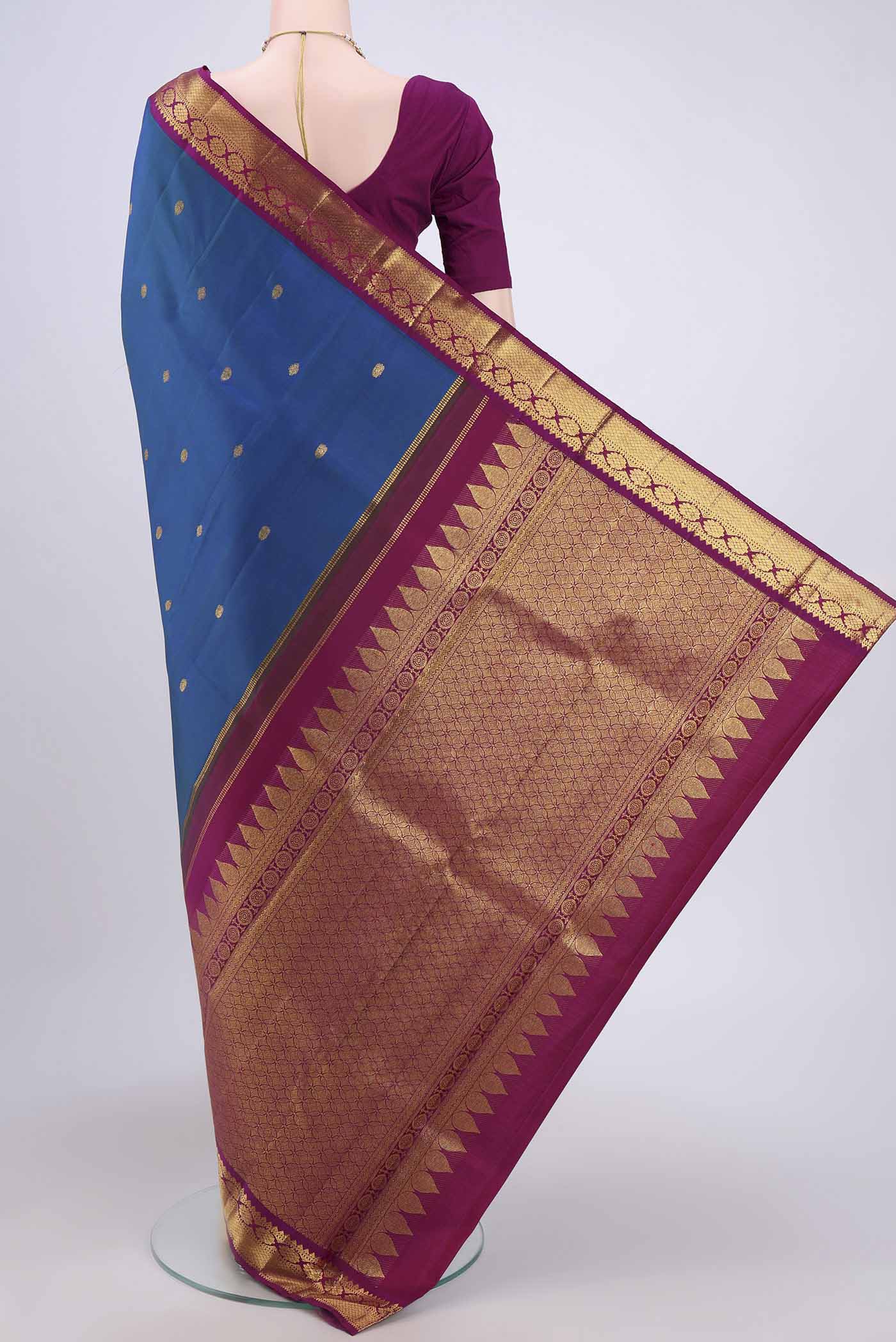 Flat view of Peacock Blue Kanchipuram Saree with Zari Butta on the body and Zari Border. 