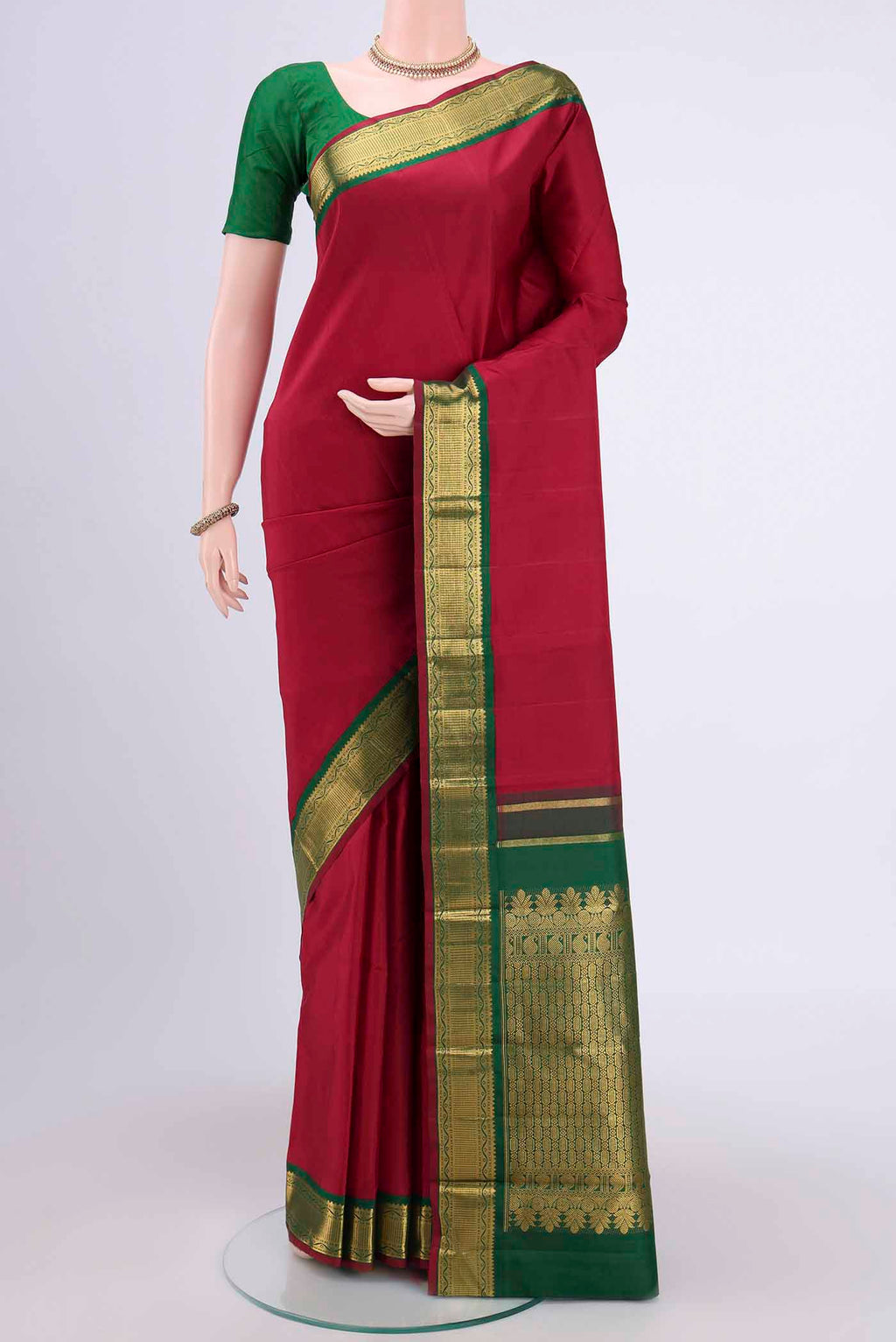 Maroon Kanchipuram Saree with Plain Body and Zari Border.  displayed on a mannequin