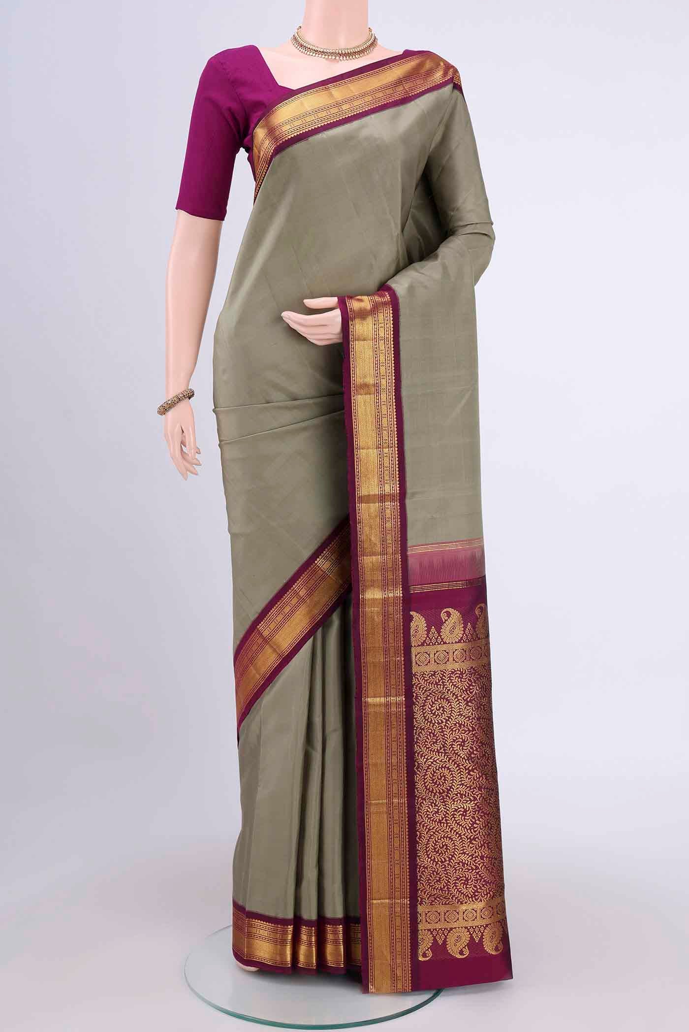 Sage Green Kanchipuram Saree with Plain Body and Zari Border.  displayed on a mannequin