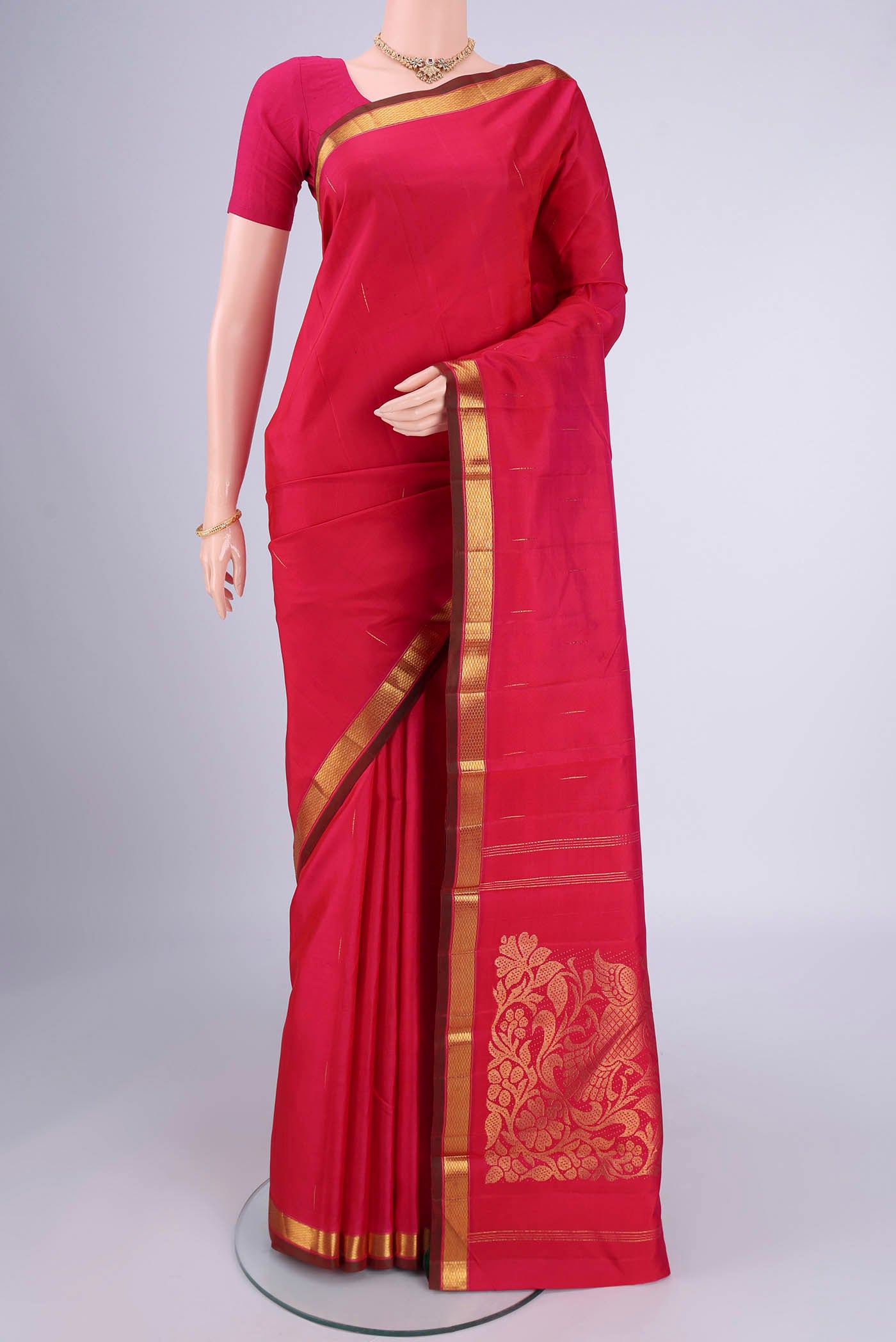 Rani Pink Kanjivaram Silk Saree with Zari Butta on the body and Zari Border.  displayed on a mannequin