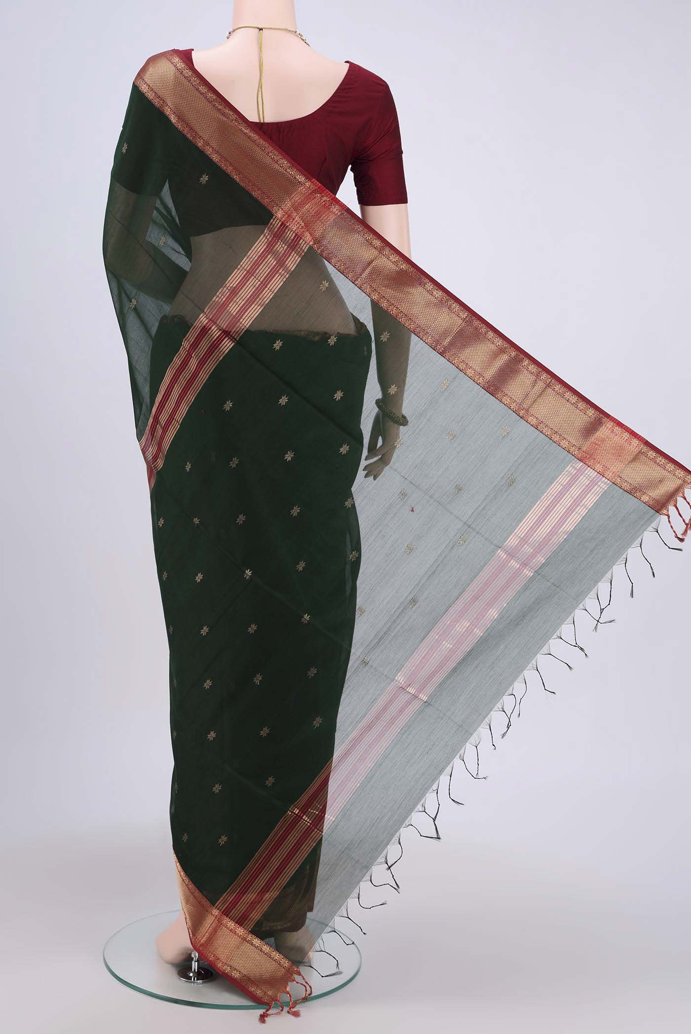 Flat view of Bottle Green Maheshwari Silk Cotton Saree with Zari Butta on the body and Zari Border. 