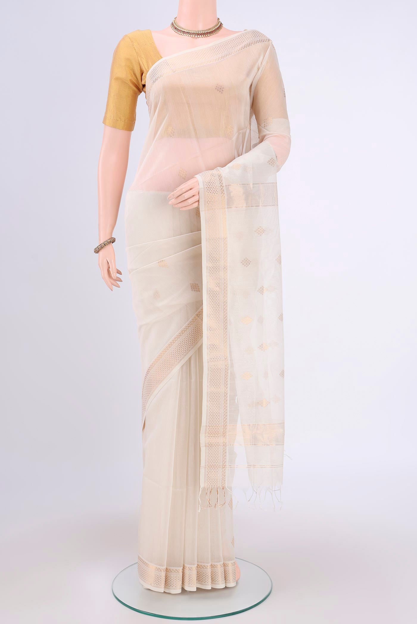 Off White Maheshwari Silk Cotton Saree with Zari Butta on the body and Zari Border.  displayed on a mannequin