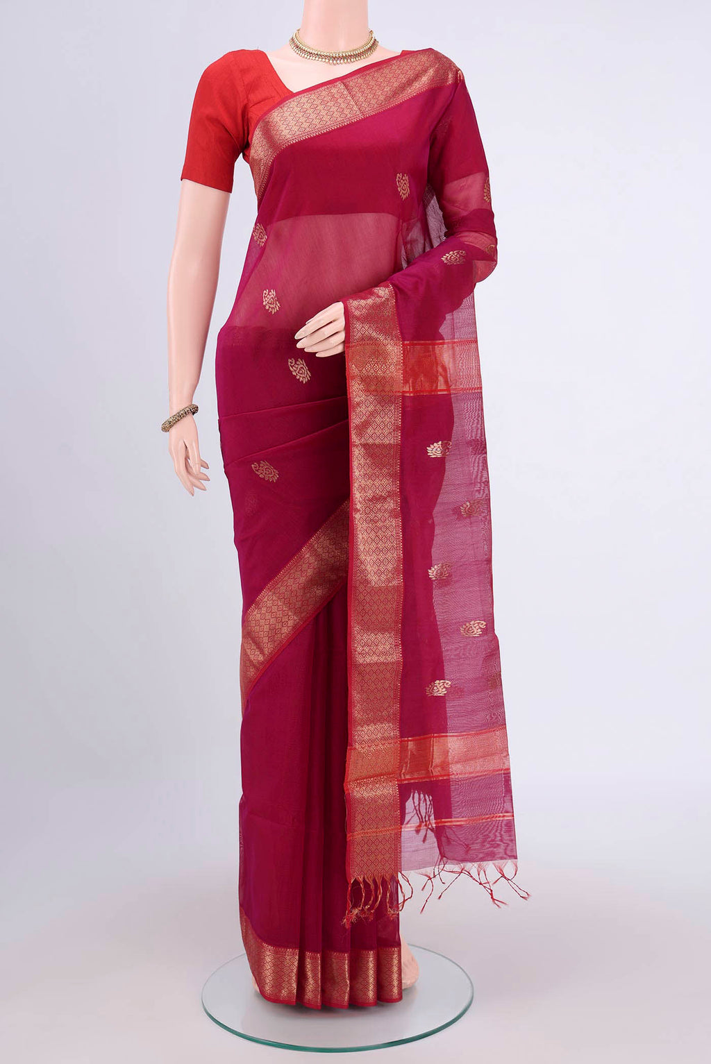 Magenta Maheshwari Silk Cotton Saree with Zari Butta on the body and Zari Border.  displayed on a mannequin