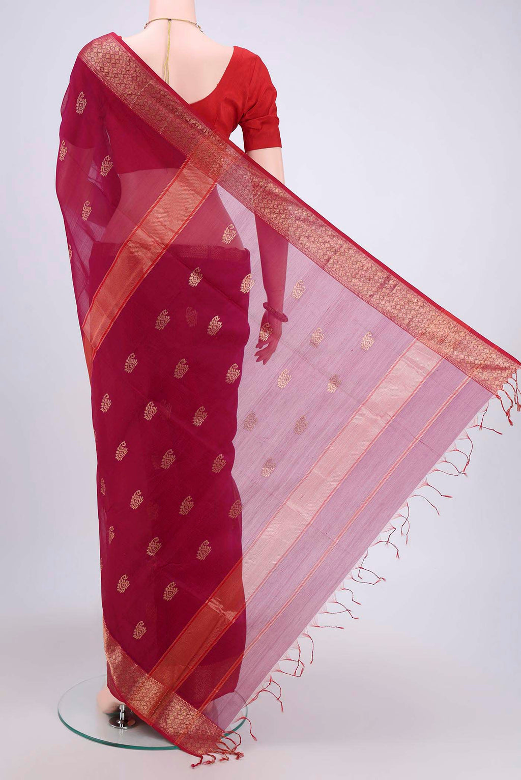 Flat view of Magenta Maheshwari Silk Cotton Saree with Zari Butta on the body and Zari Border. 