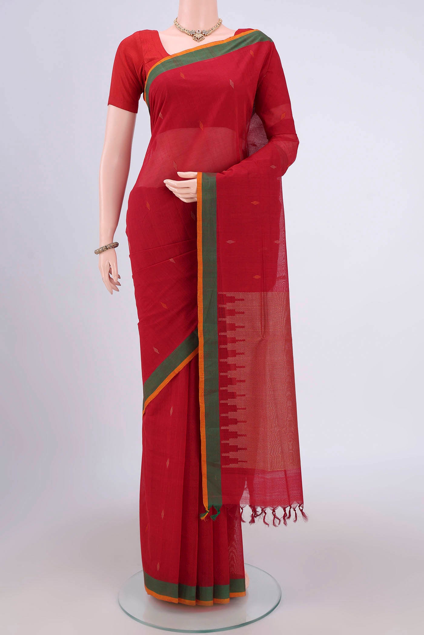 Red Coimbatore Cotton Saree with Thread Butta on the body and Zari Border.  displayed on a mannequin