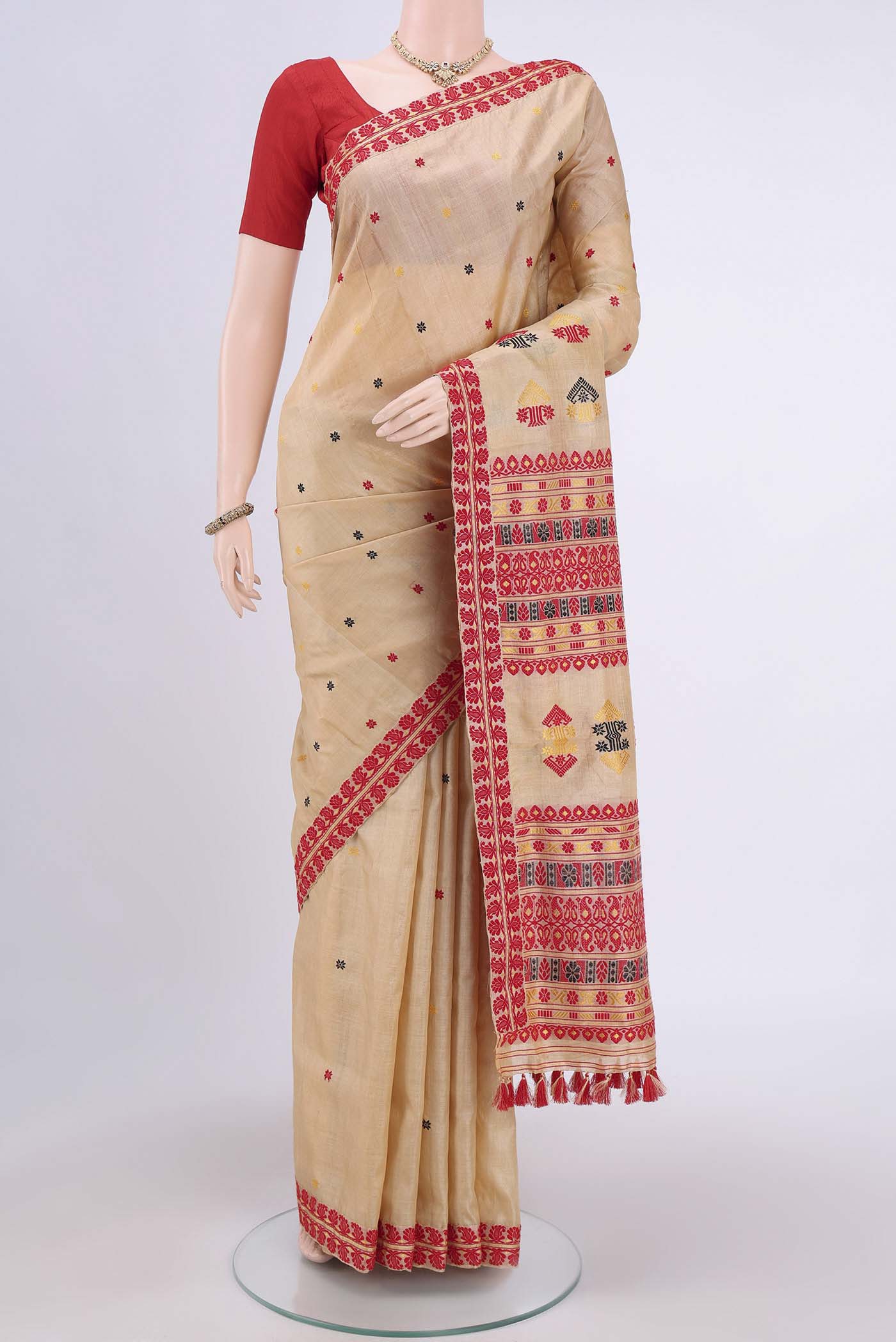 Dark Beige Assam Silk Saree with Thread Butta on the body and Thread Border.  displayed on a mannequin