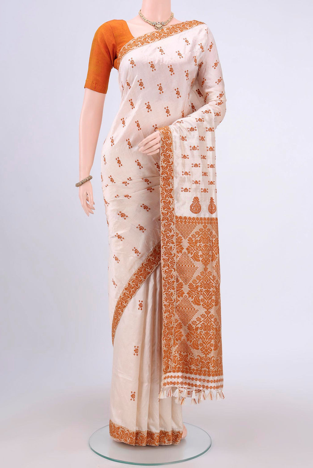 Cream Assam Silk Saree with Thread Butta on the body and Thread Border.  displayed on a mannequin