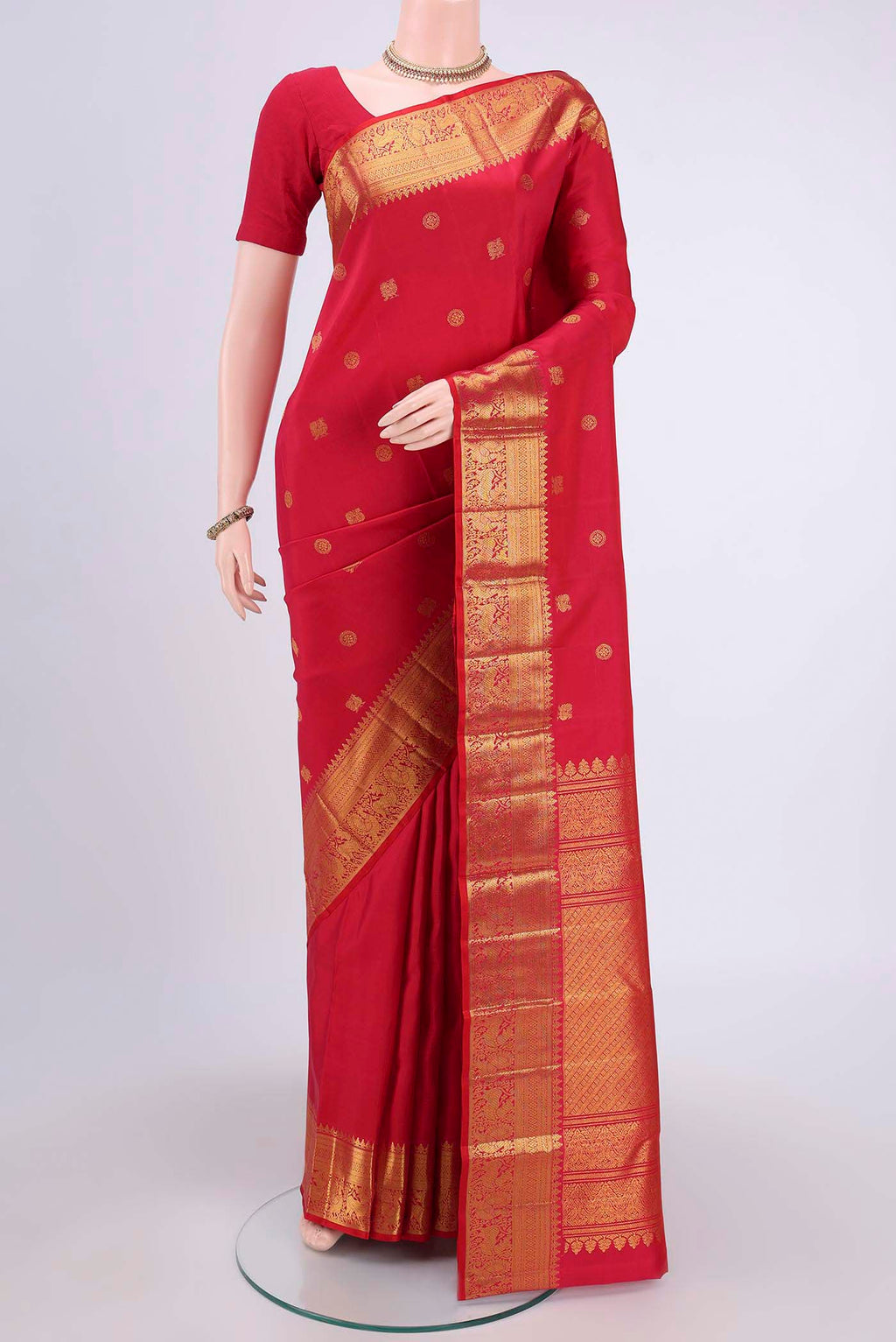 Red Kanjivaram Saree with Zari Butta on the body and Zari Border.  displayed on a mannequin