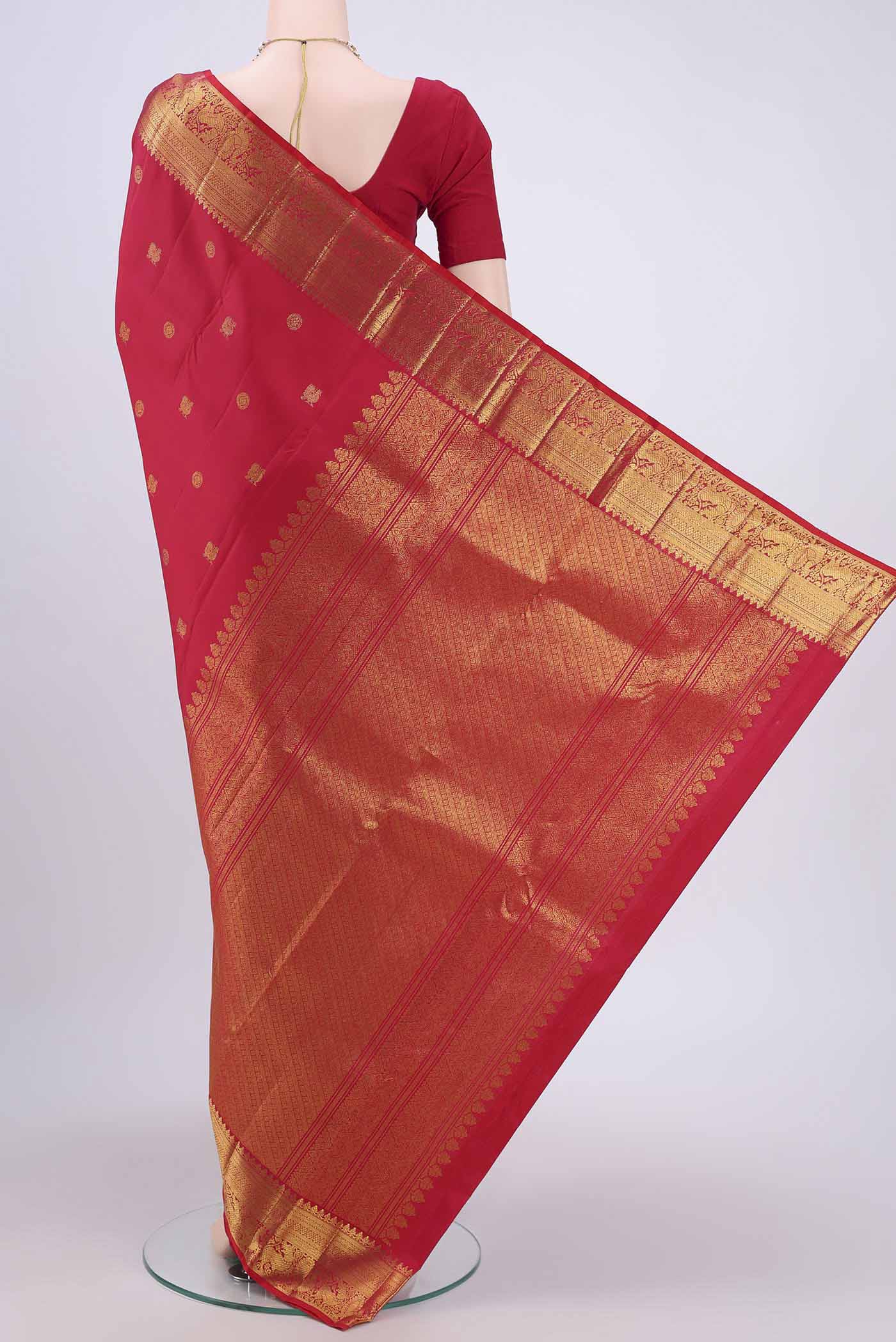 Flat view of Red Kanjivaram Saree with Zari Butta on the body and Zari Border. 