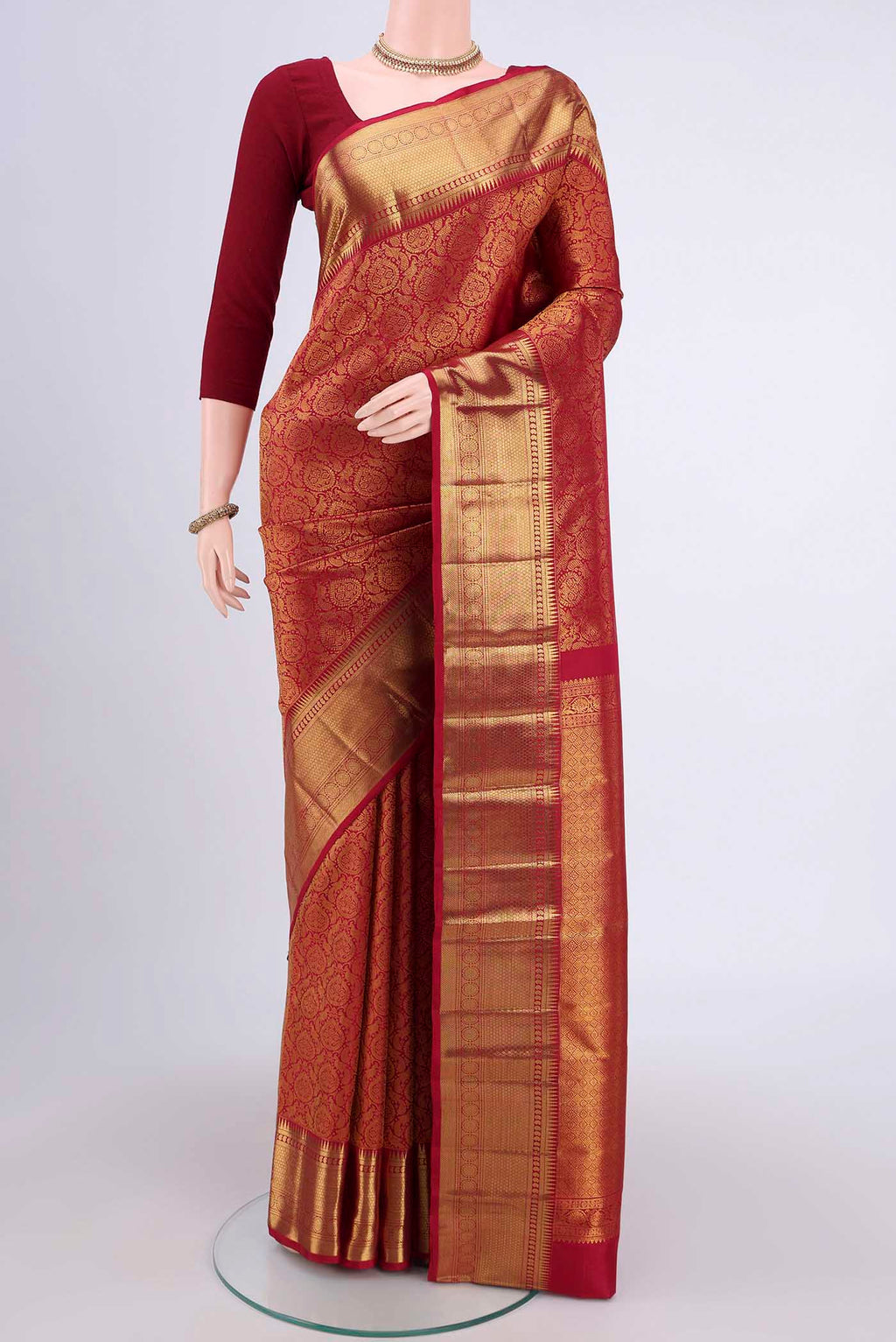 Maroon Kanchipuram Saree with Zari Brocade on the body and Zari Border.  displayed on a mannequin