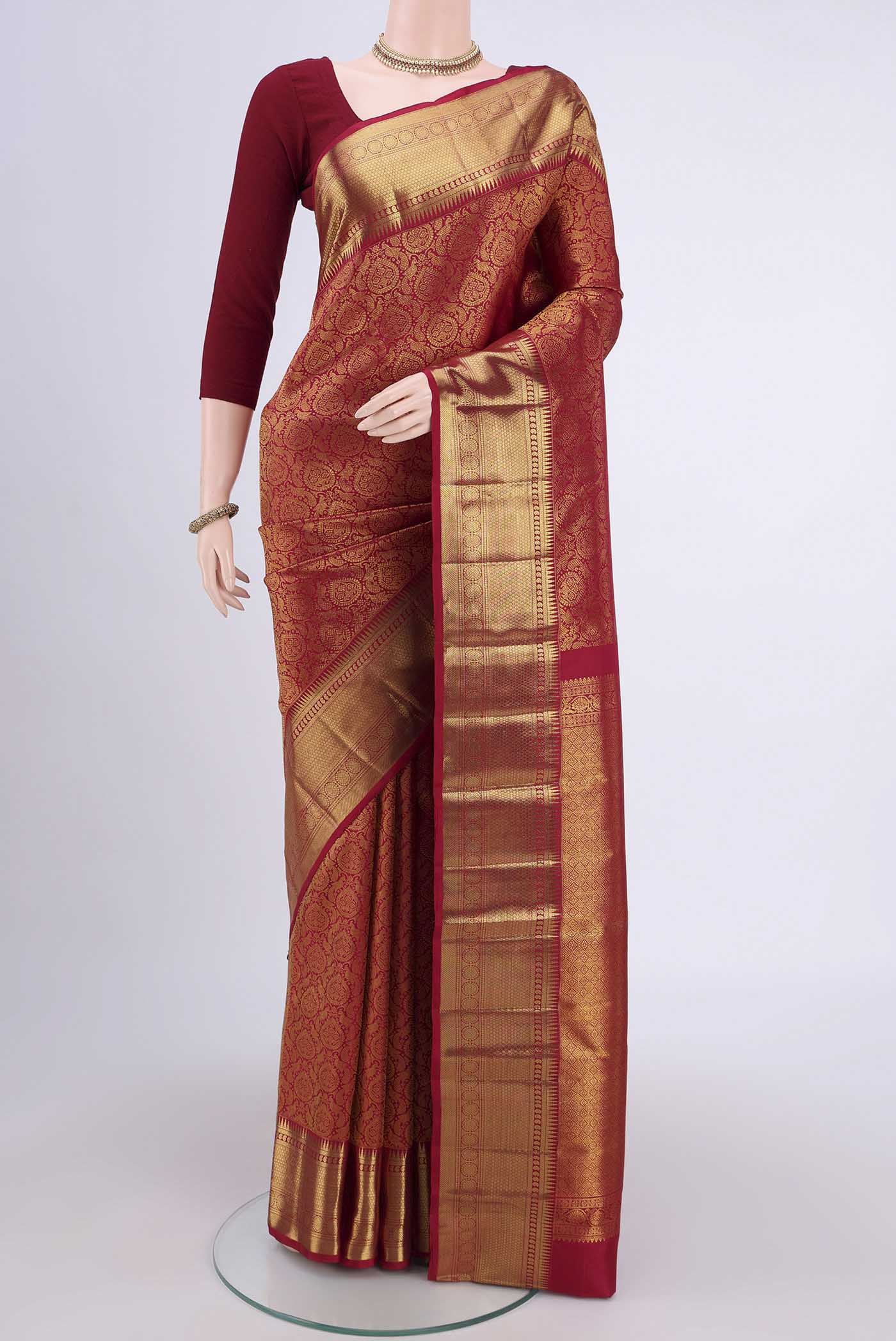 Maroon Kanchipuram Saree with Zari Brocade on the body and Zari Border.  displayed on a mannequin