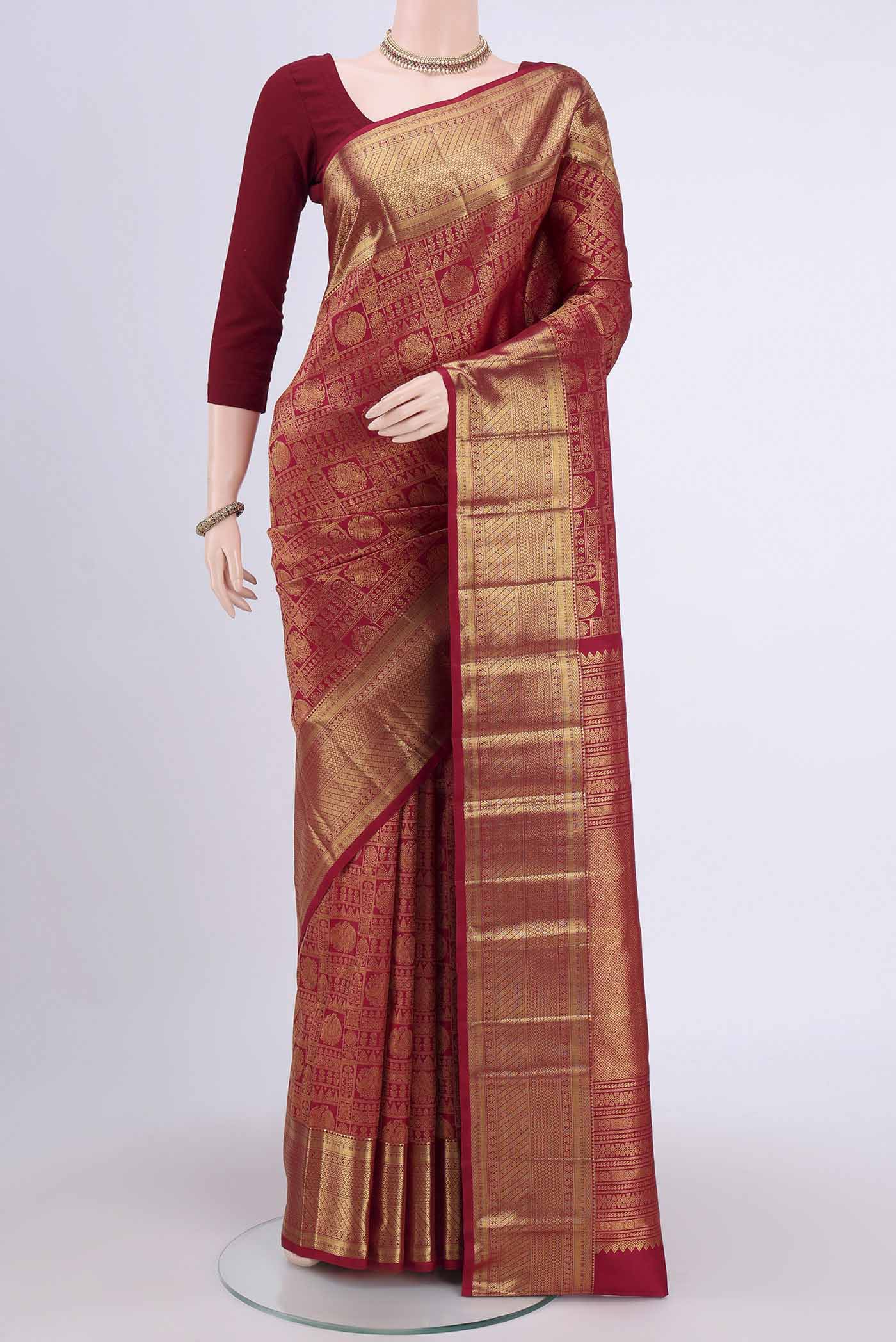 Maroon Kanchipuram Saree with Zari Brocade on the body and Rising Temple Border.  displayed on a mannequin