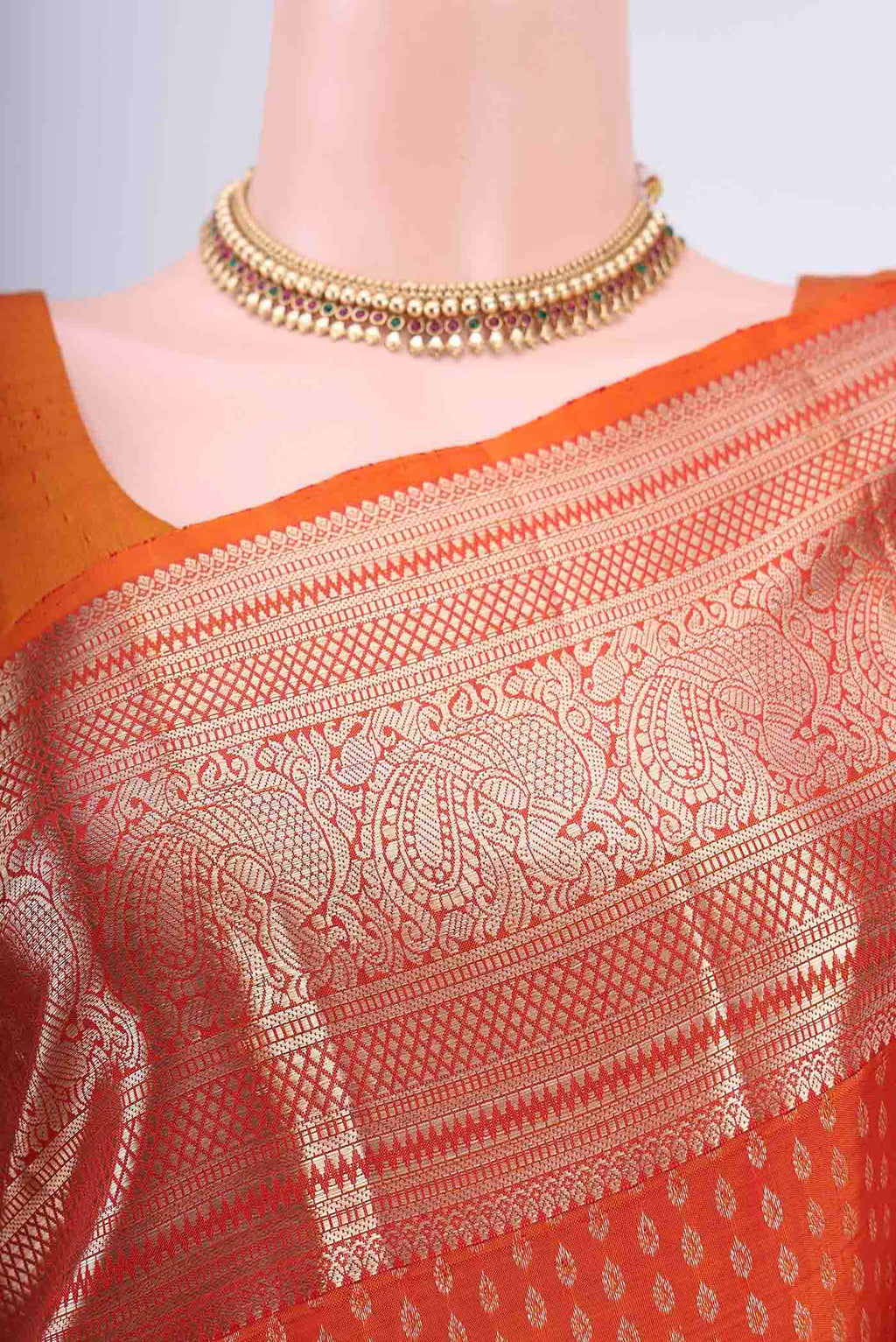Border image of Rust Kanchipuram Saree with Zari Butta on the body and Zari Border. 