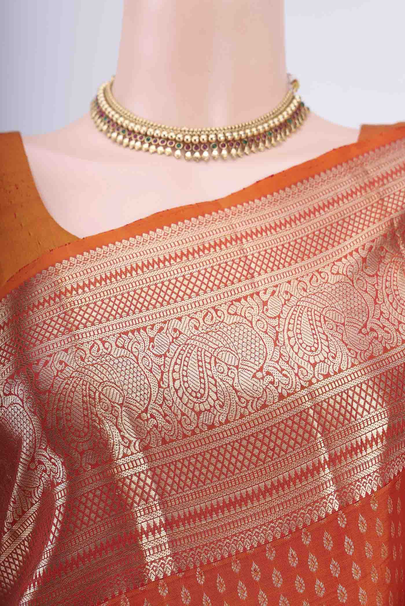 Border image of Rust Kanchipuram Saree with Zari Butta on the body and Zari Border. 