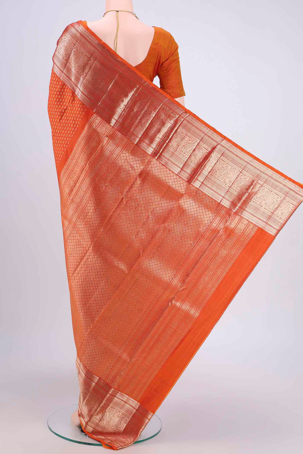 Flat view of Rust Kanchipuram Saree with Zari Butta on the body and Zari Border. 