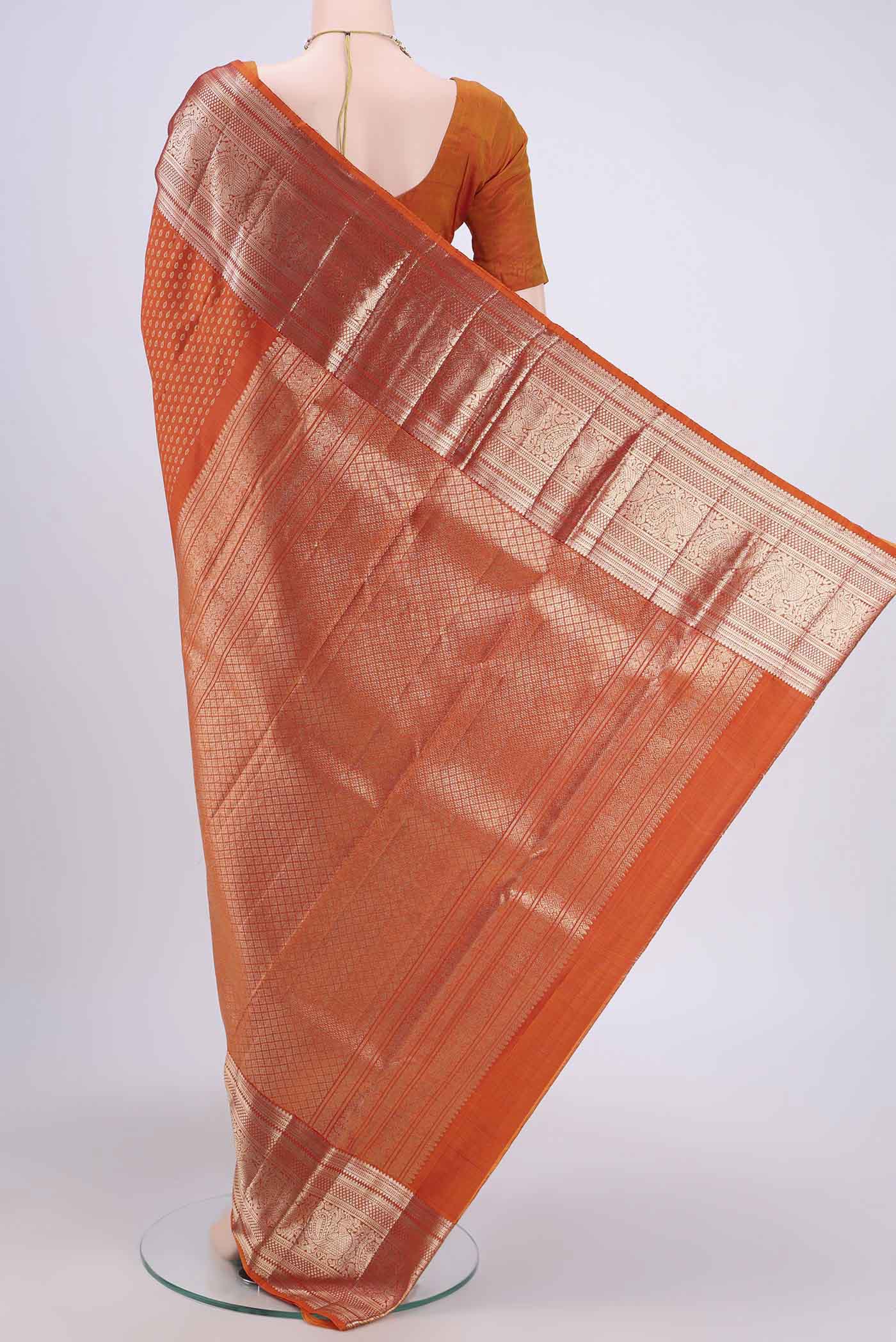 Flat view of Rust Kanchipuram Saree with Zari Butta on the body and Zari Border. 
