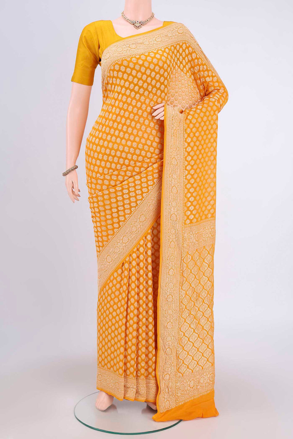 Yellow Banarasi Georgette Saree with Zari Brocade on the body and Zari Border.  displayed on a mannequin