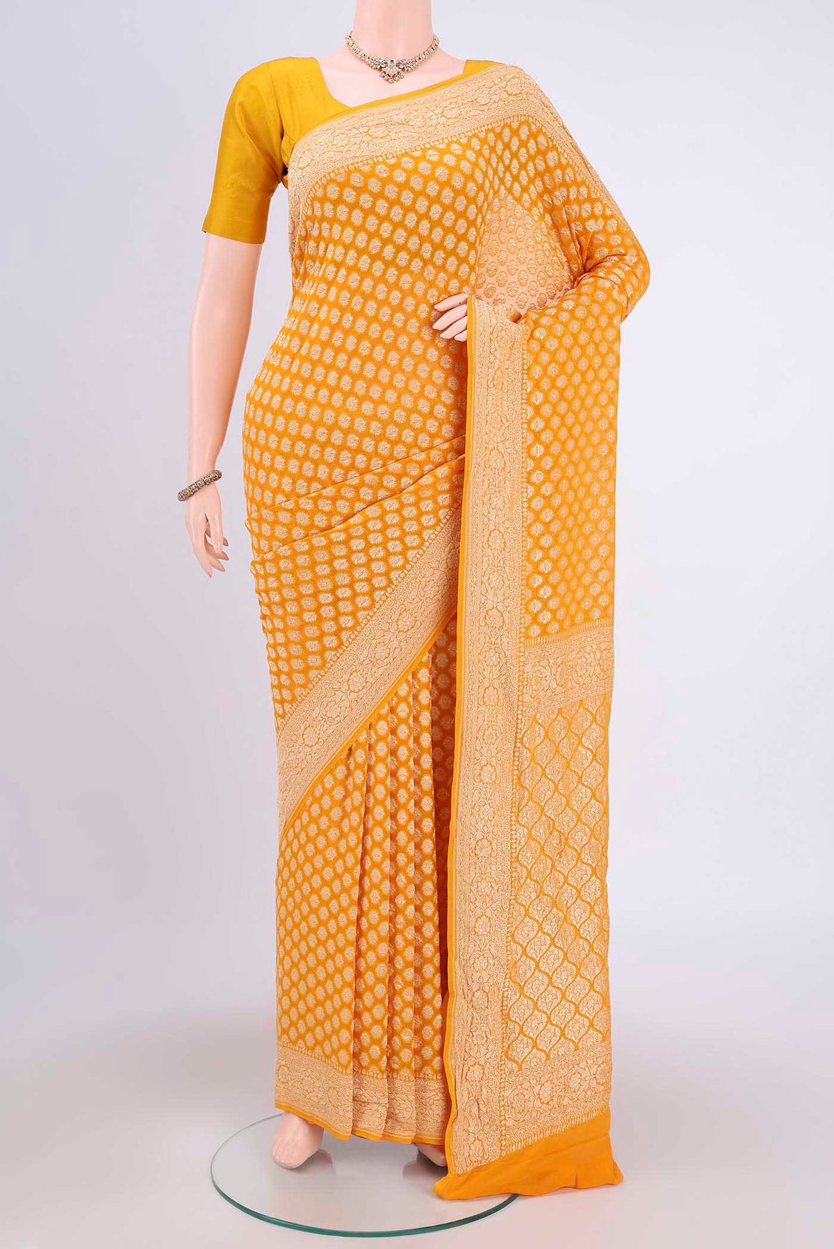 Yellow Banarasi Georgette Saree with Zari Brocade on the body and Zari Border.  displayed on a mannequin