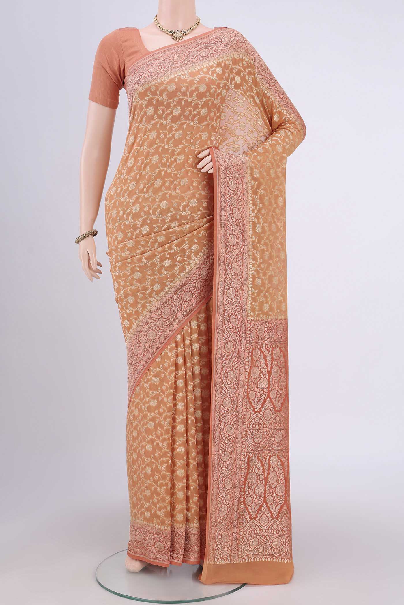 Peach Banarasi Georgette Saree with Zari Brocade on the body and Zari Border.  displayed on a mannequin