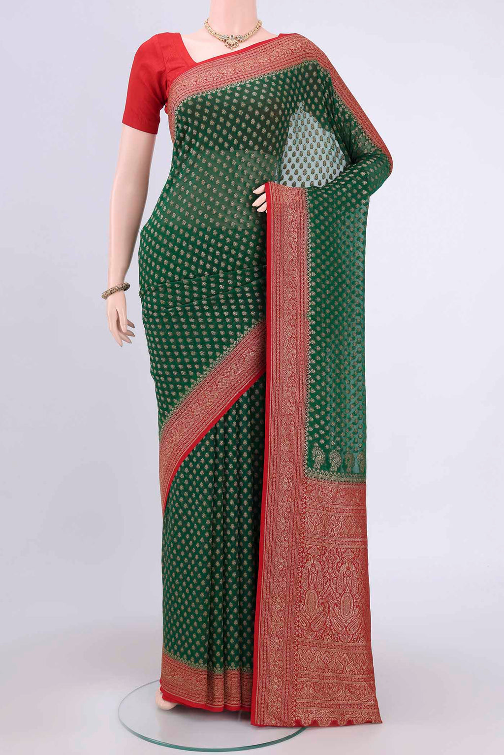Bottle Green Banarasi Georgette Saree with Zari Brocade on the body and Zari Border.  displayed on a mannequin