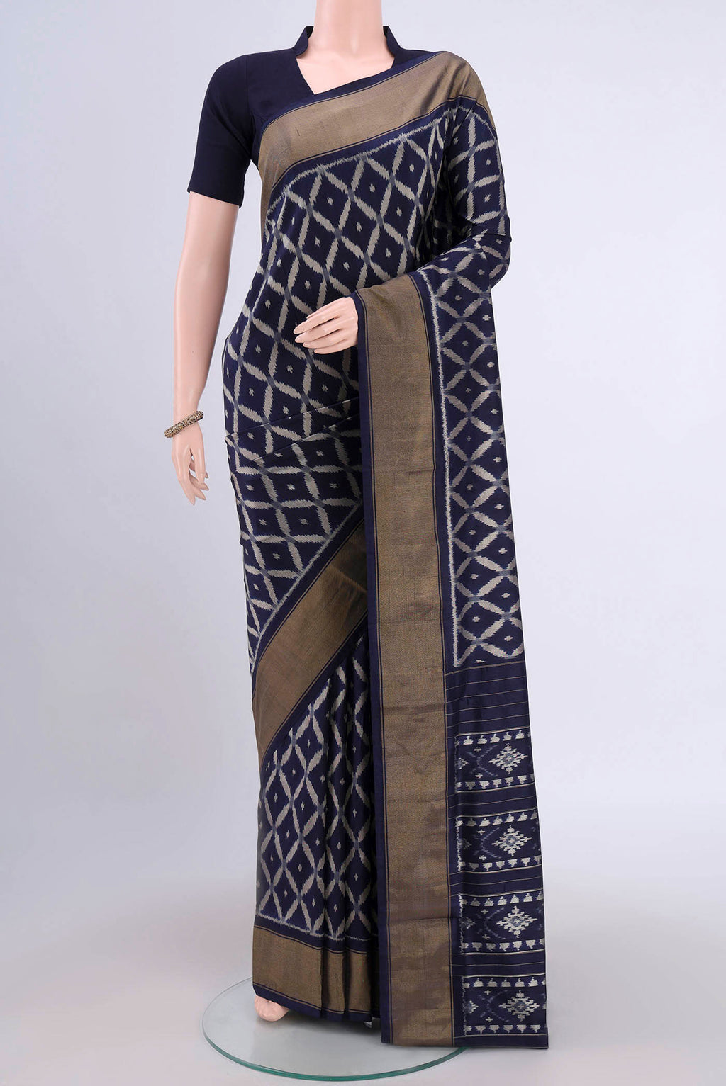 Brown Pochampally Silk Saree with Pure Ikat on the body and Zari Border.  displayed on a mannequin