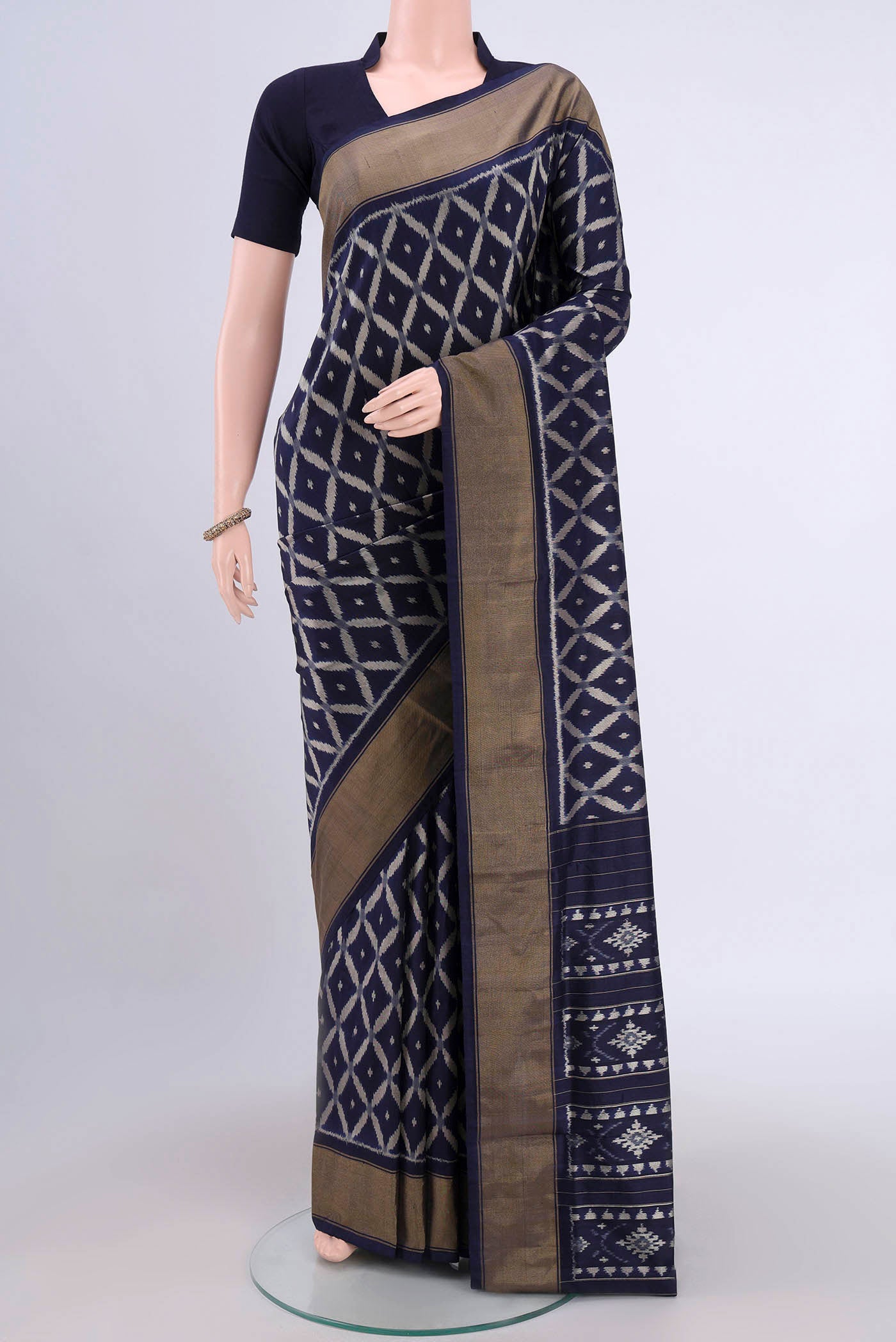 Brown Pochampally Silk Saree with Pure Ikat on the body and Zari Border.  displayed on a mannequin
