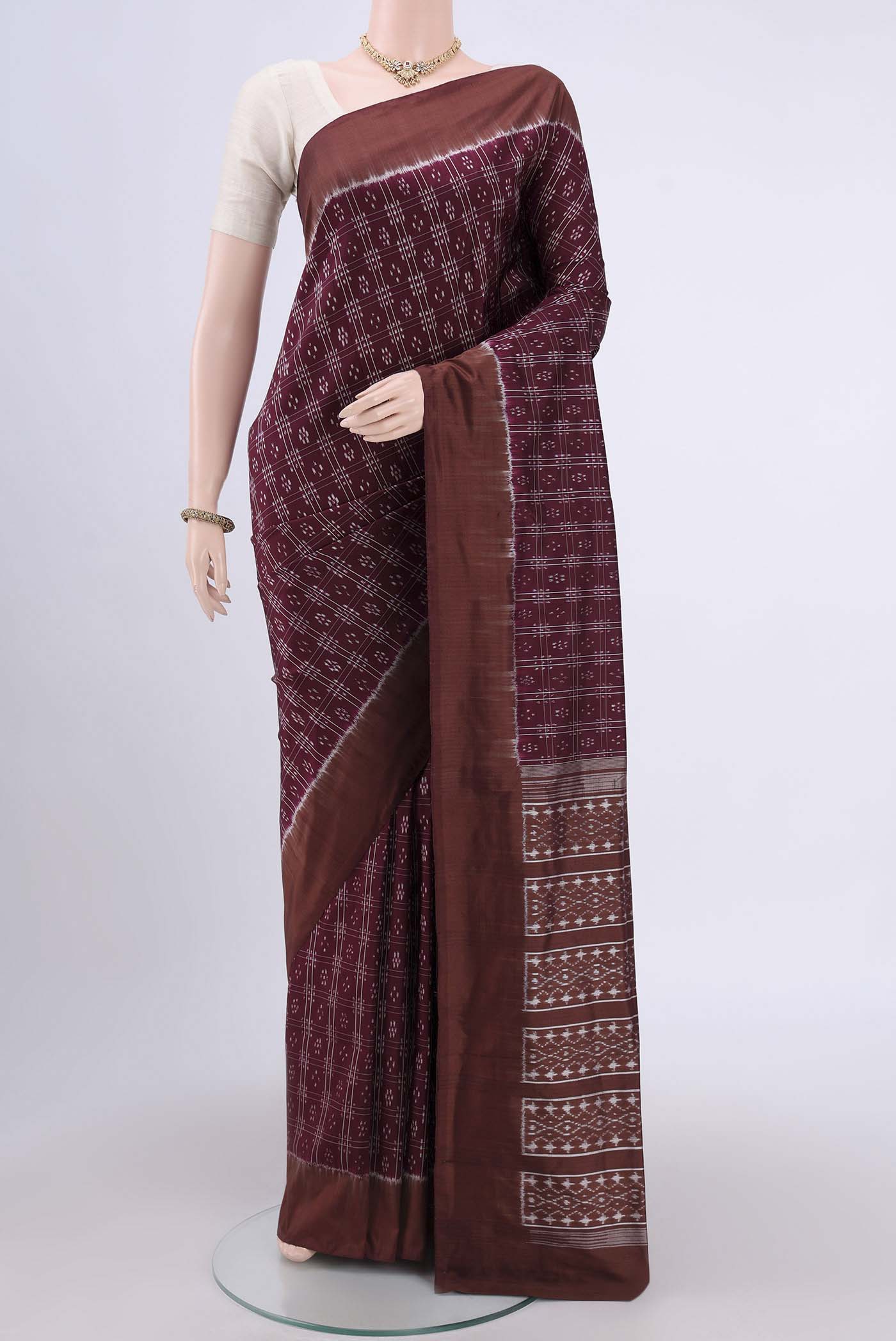 Burgundy Pochampally Silk Saree with Checked design on the body and Plain Border.  displayed on a mannequin