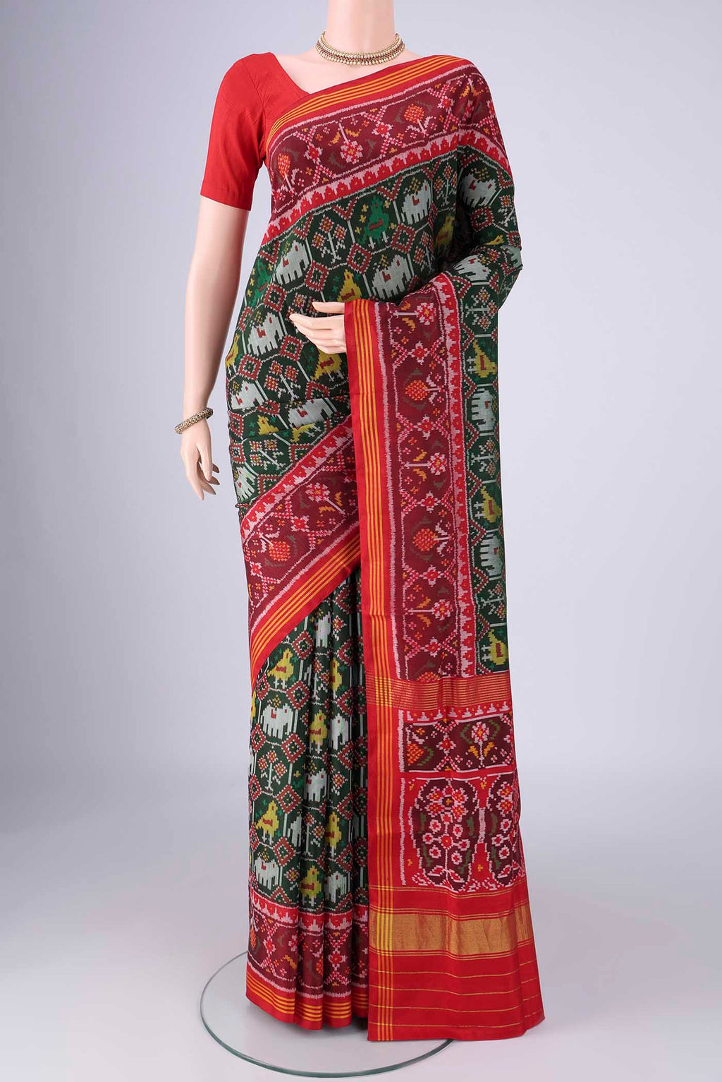 Bottle Green Rajkot Patola Silk Saree with Pure Ikat on the body and Ikat Border.  displayed on a mannequin