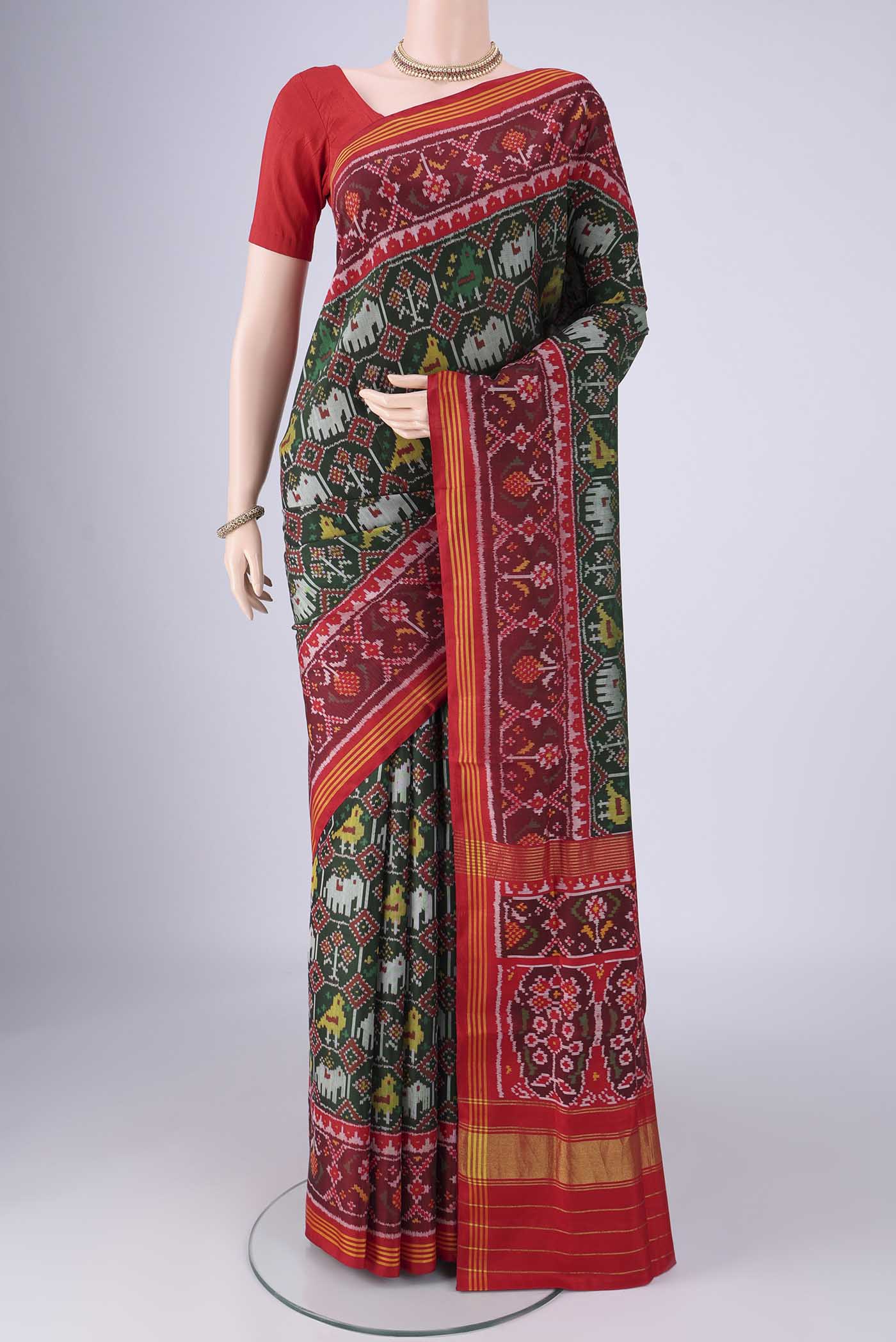 Bottle Green Rajkot Patola Silk Saree with Pure Ikat on the body and Ikat Border.  displayed on a mannequin