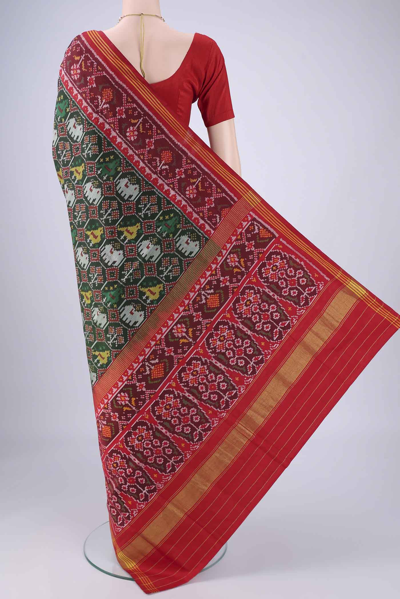 Flat view of Bottle Green Rajkot Patola Silk Saree with Pure Ikat on the body and Ikat Border. 