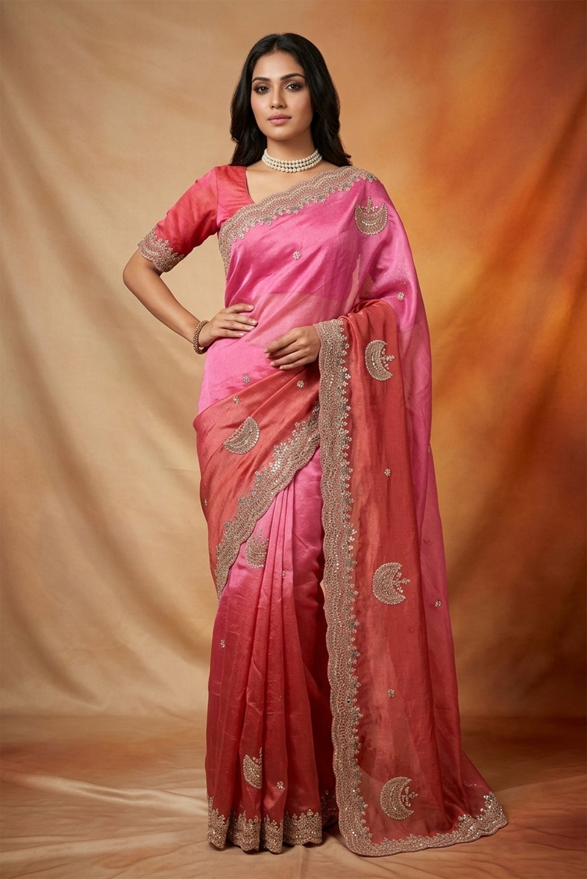 Model wearing a Pink and  Dark Coral Color Organza Silk Saree with Embroidery on the body and Embroidery Border.