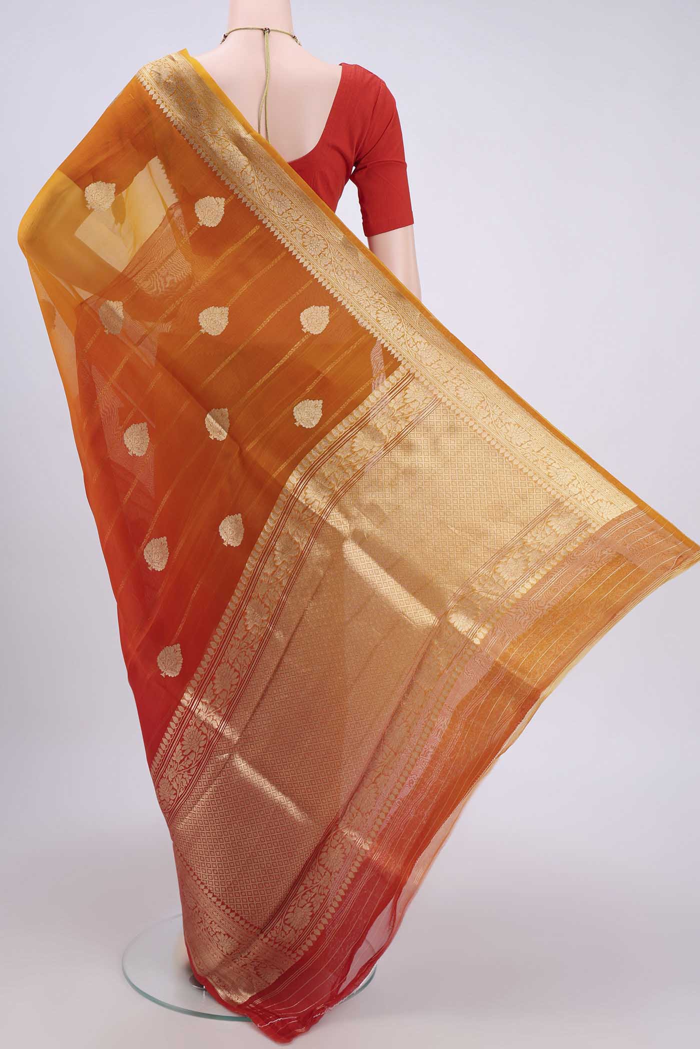 Flat view of Rust Organza Silk Saree with Half And Half on the body and Zari Border. 