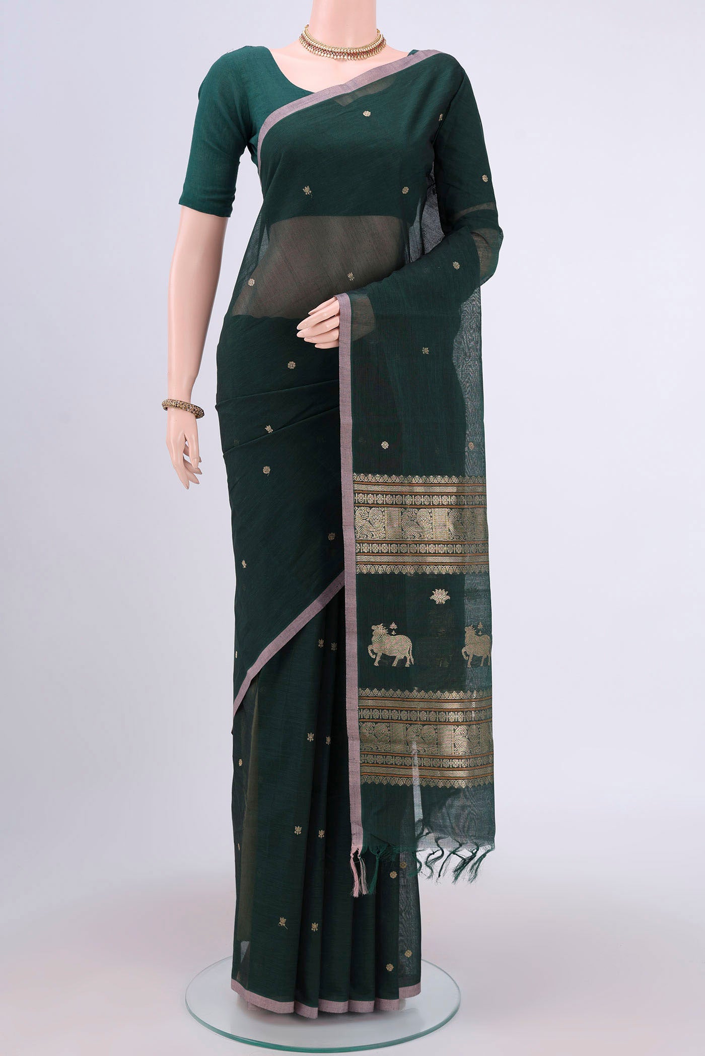 Bottle Green Kanchi Cotton Saree with Zari Butta on the body and Zari Border.  displayed on a mannequin