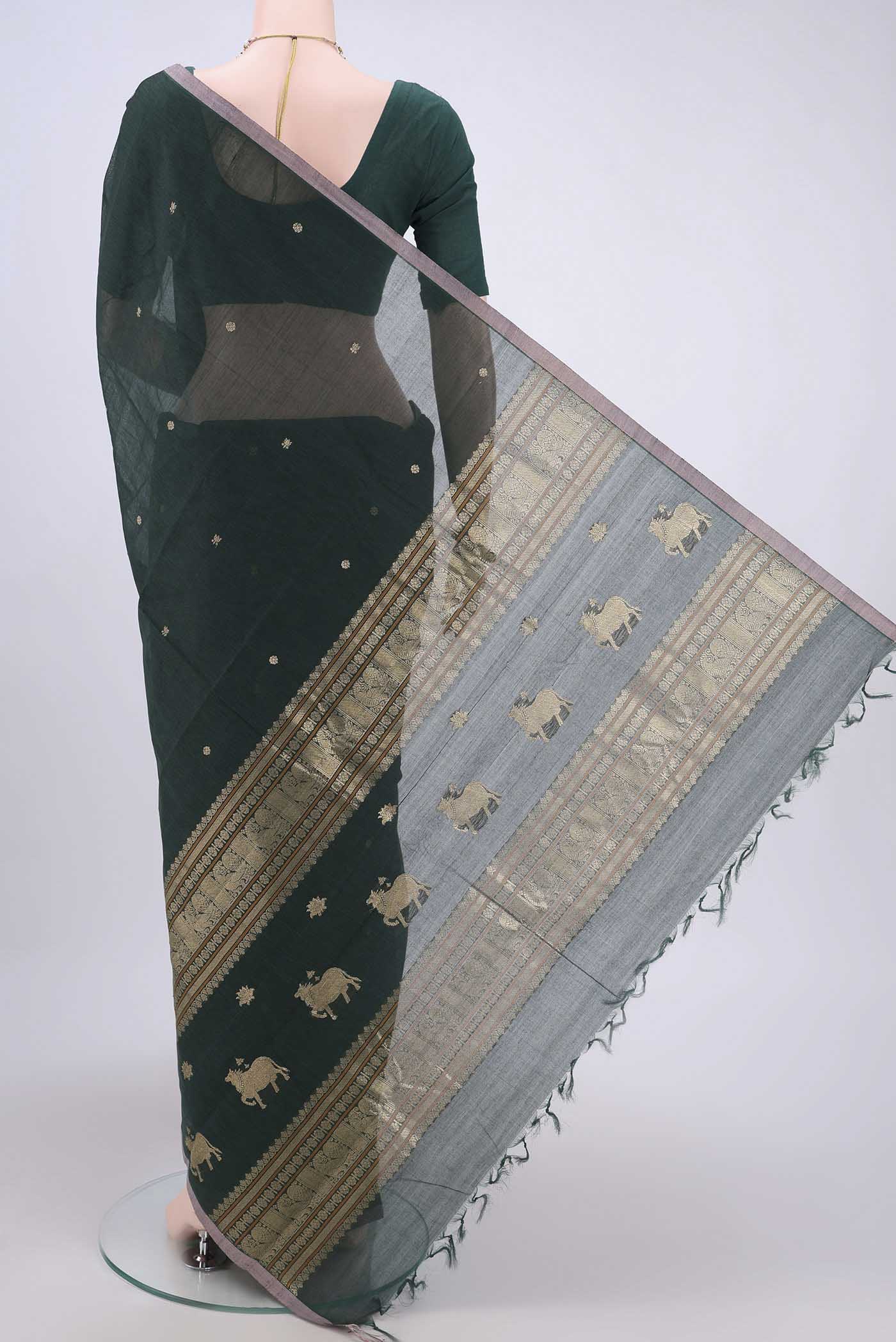 Flat view of Bottle Green Kanchi Cotton Saree with Zari Butta on the body and Zari Border. 