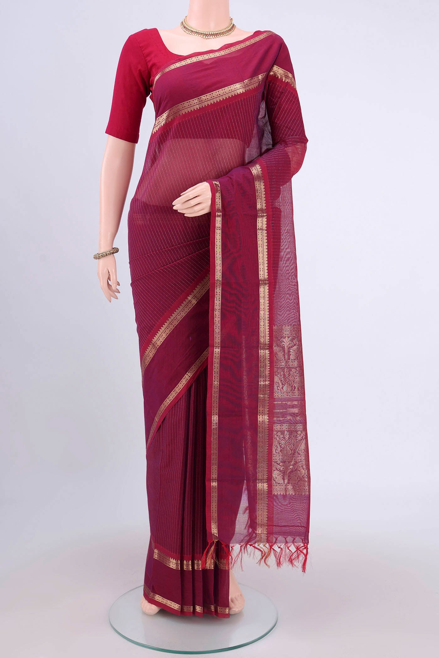 Dark Pink Kanchi Cotton Saree with Stripes on the body and Zari Border.  displayed on a mannequin