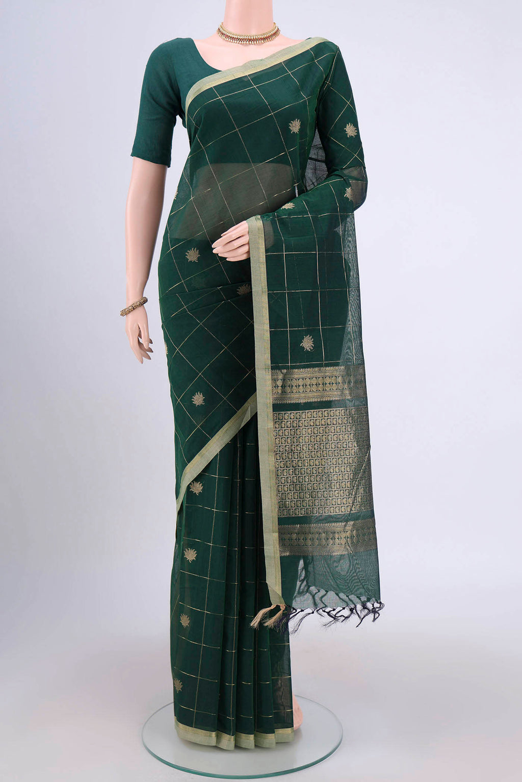Bottle Green Kanchi Cotton Saree with Checked design on the body and Zari Border.  displayed on a mannequin