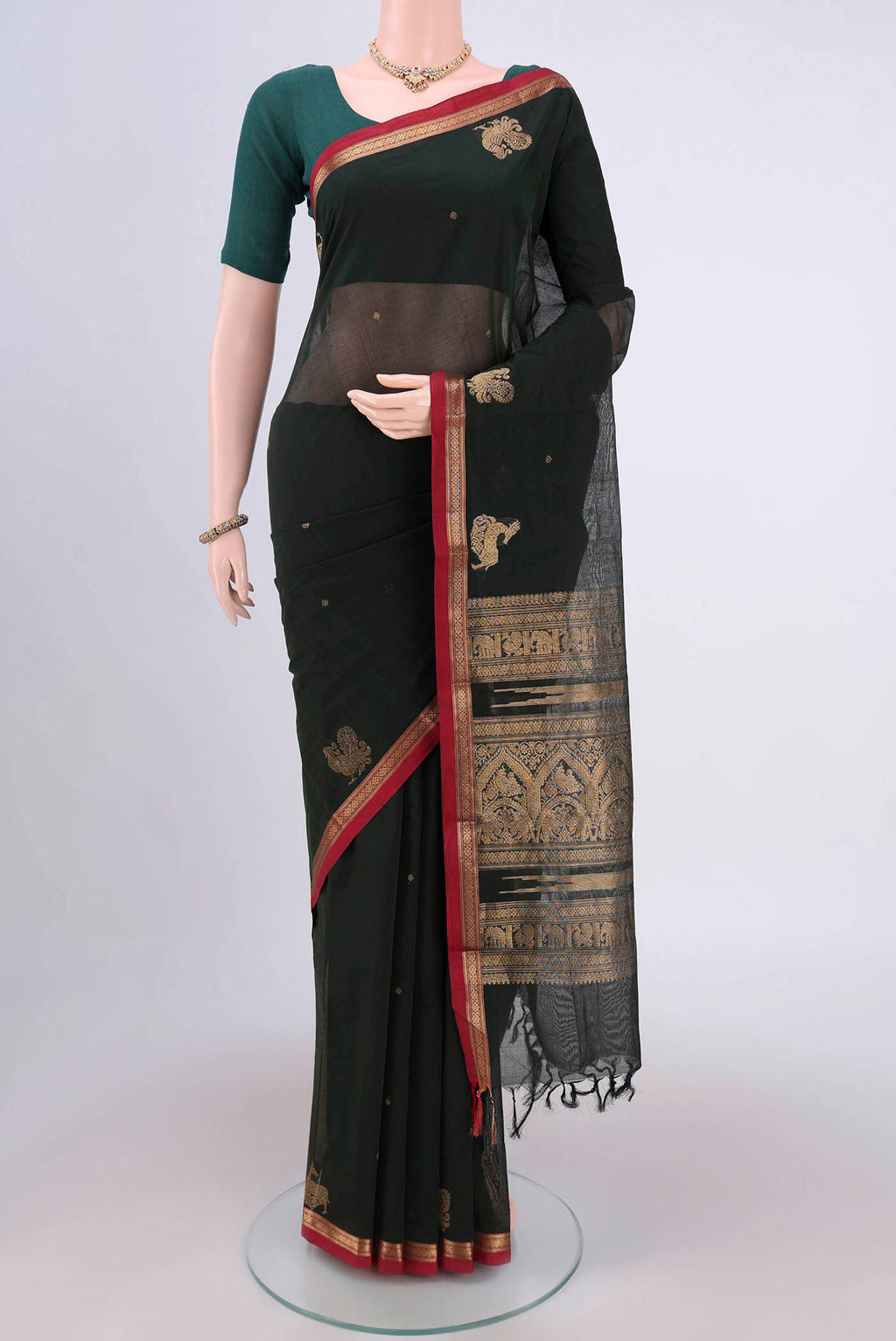 Bottle Green Kanchi Cotton Saree with Zari Butta on the body and Zari Border.  displayed on a mannequin